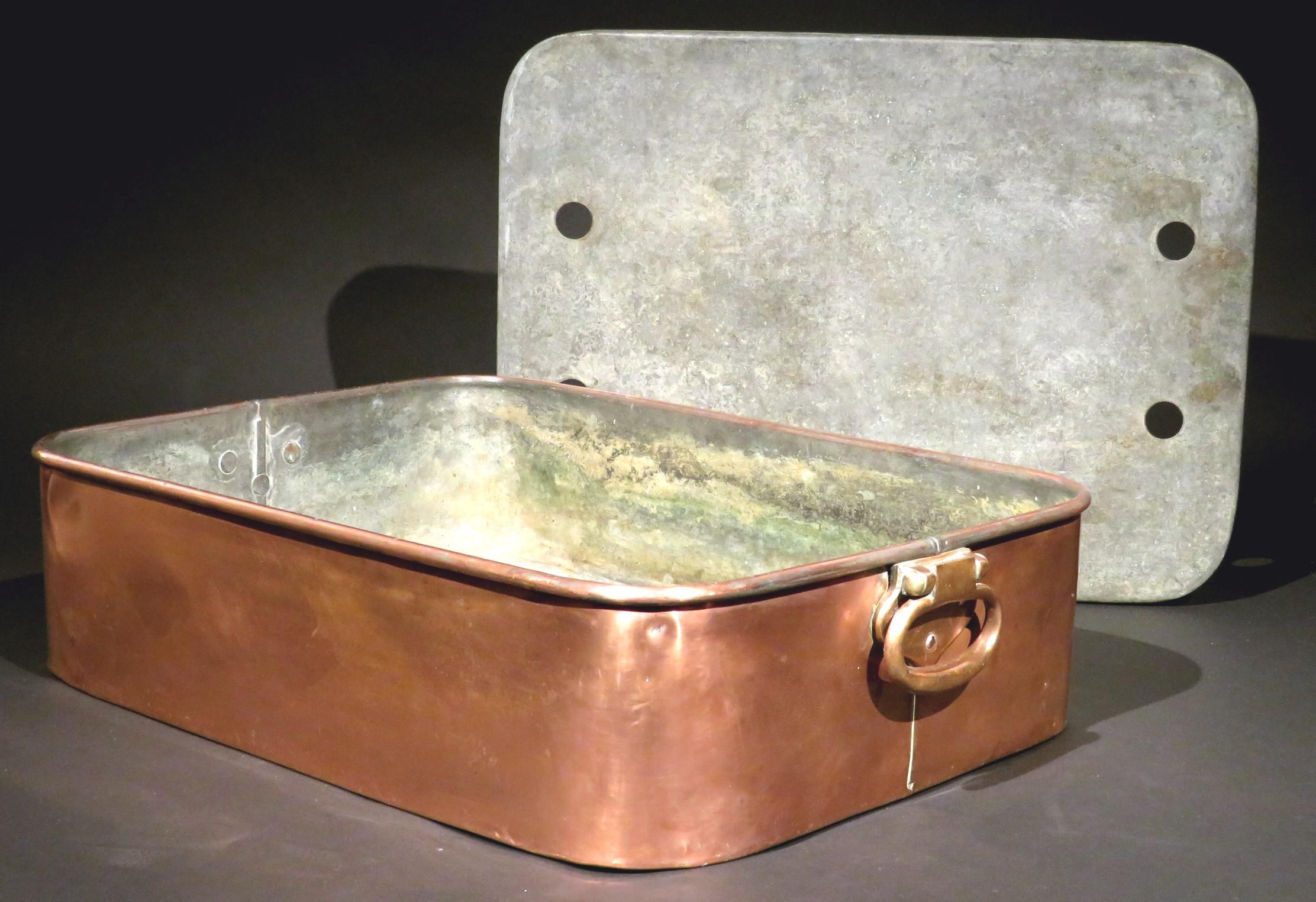 A large & heavy gauge antique copper bain-marie / poaching pan retaining its original tinned mazarine, the ends having rivet mounted barrel-hinged handles. 
In addition to its intended use, this attractive piece of antique copper kitchenware  would