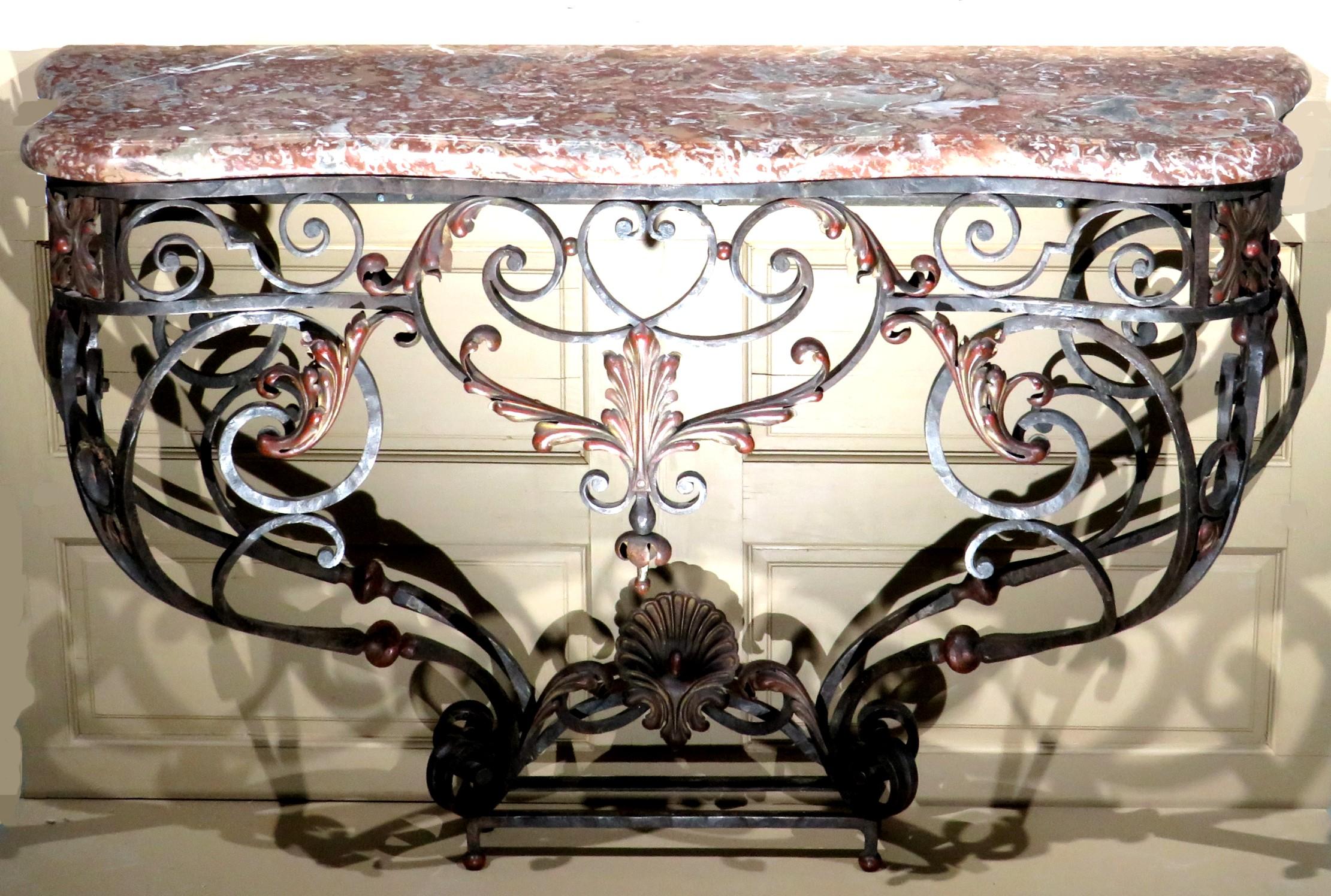 A very handsome 'Belle Epoque' Period wrought iron console table in the Louis XV style. The original curvilinear shaped ‘breche violette’ marble top having a molded edge, resting upon its conforming hand forged, wrought iron base comprised of