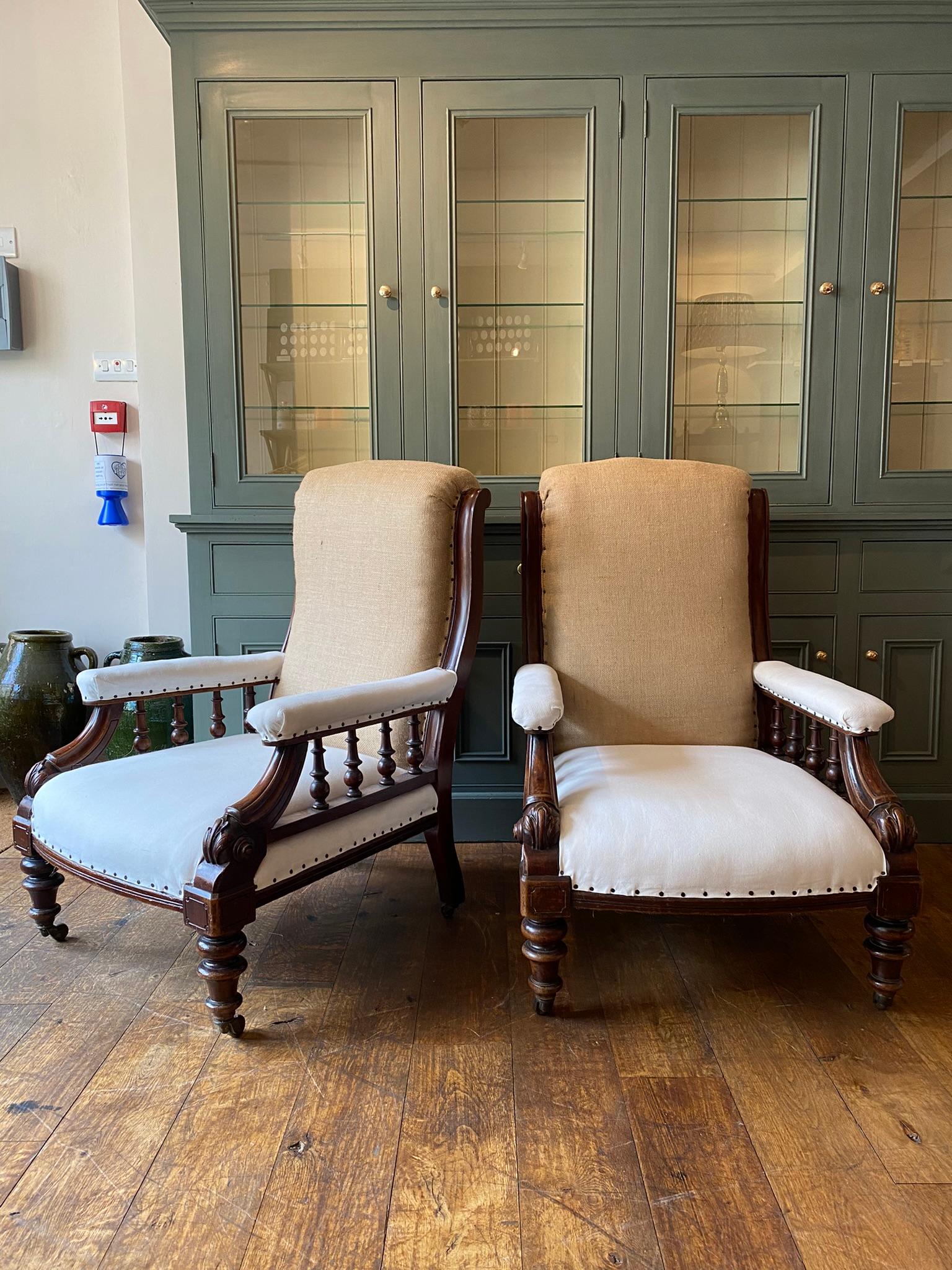 A fine pair of English show framed library chairs. Open arms with 4 turned balustrades, carving to the arms and turned front legs. Sitting upon 4 ceramic castors. 

The chairs have been reupholstered using calico and hessian ready for the top cover,