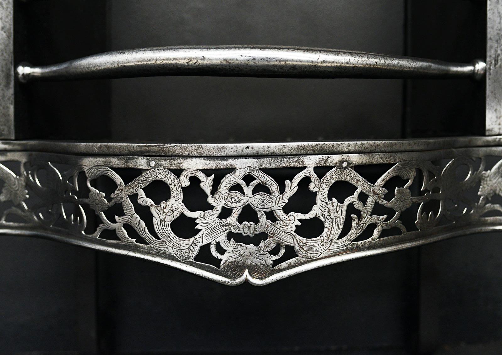 A very good quality English Georgian steel firegrate. The square legs surmounted by cast iron finials, the shaped fret engraved with foliage throughout surmounted by bowed front bars and finials above. English, circa 1800.

Width At Front:	703 mm   