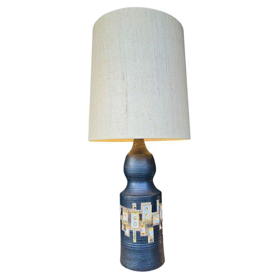 Très grande lampe en céramique des années 1960, réalisée par le céramiste français Georges Pelletier pour les célèbres Accolay Potteries. Cette grande lampe en céramique émaillée noire est un fabuleux exemple de son style unique, avec des trous