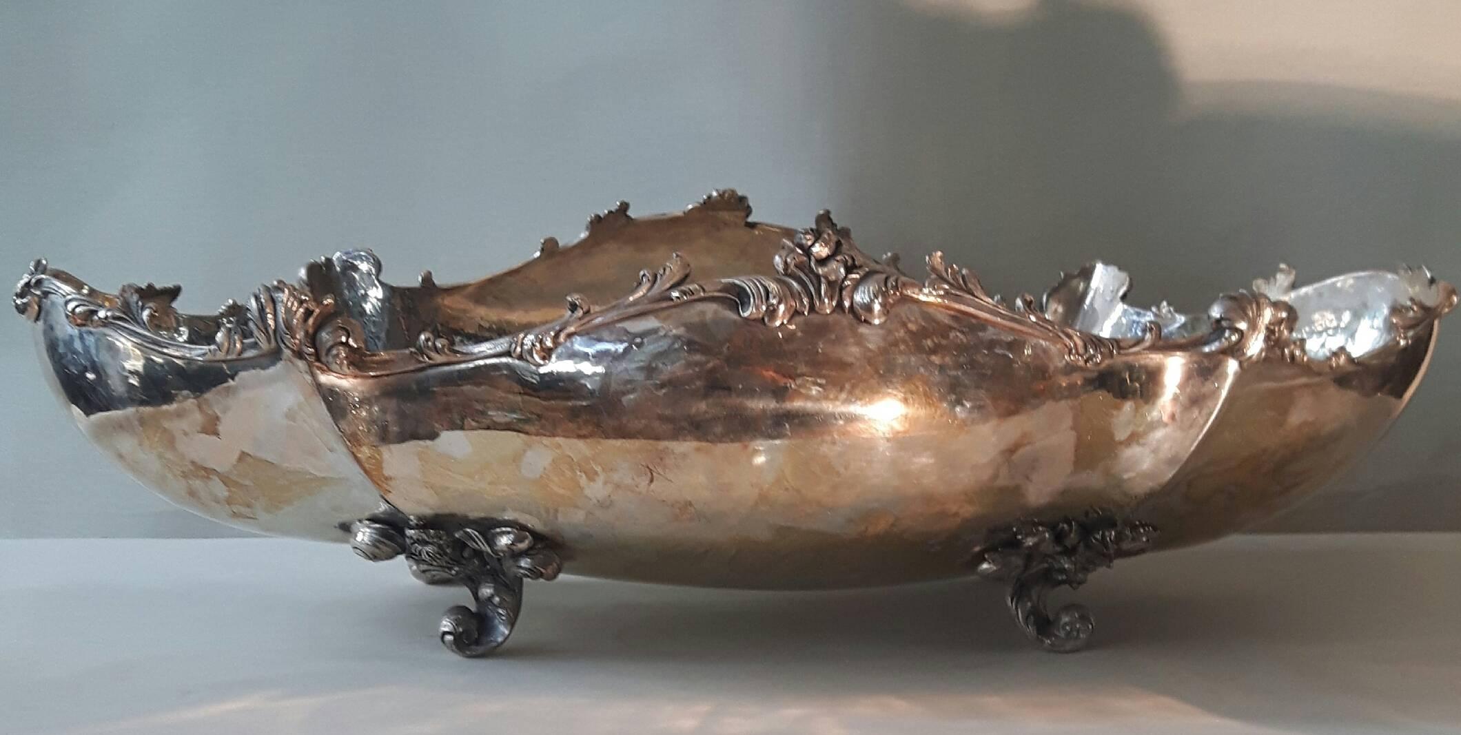 Eine große versilberte Schale aus der viktorianischen Ära, deren schlichter Korpus durch einen geschwungenen Rand und verkrustete Blumen elegant hervorgehoben wird und die auf einer geschwungenen Halterung ruht.