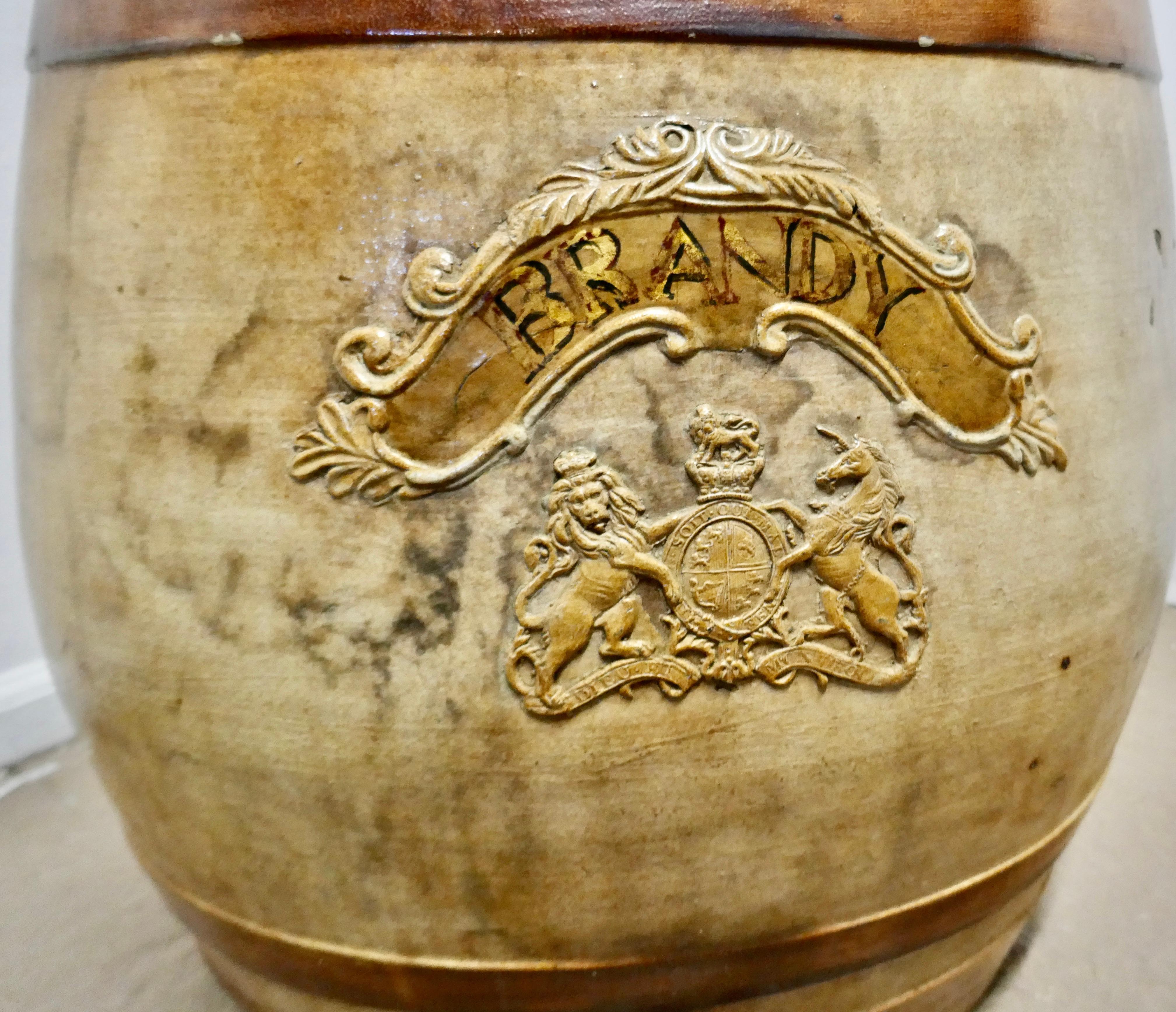 A very large stoneware brandy barrel it is in good condition with minor chips, it has the traditional hooped design with a royal appointment in embossed in relief on the front and it has a socket for a tap at the bottom

This would make a great