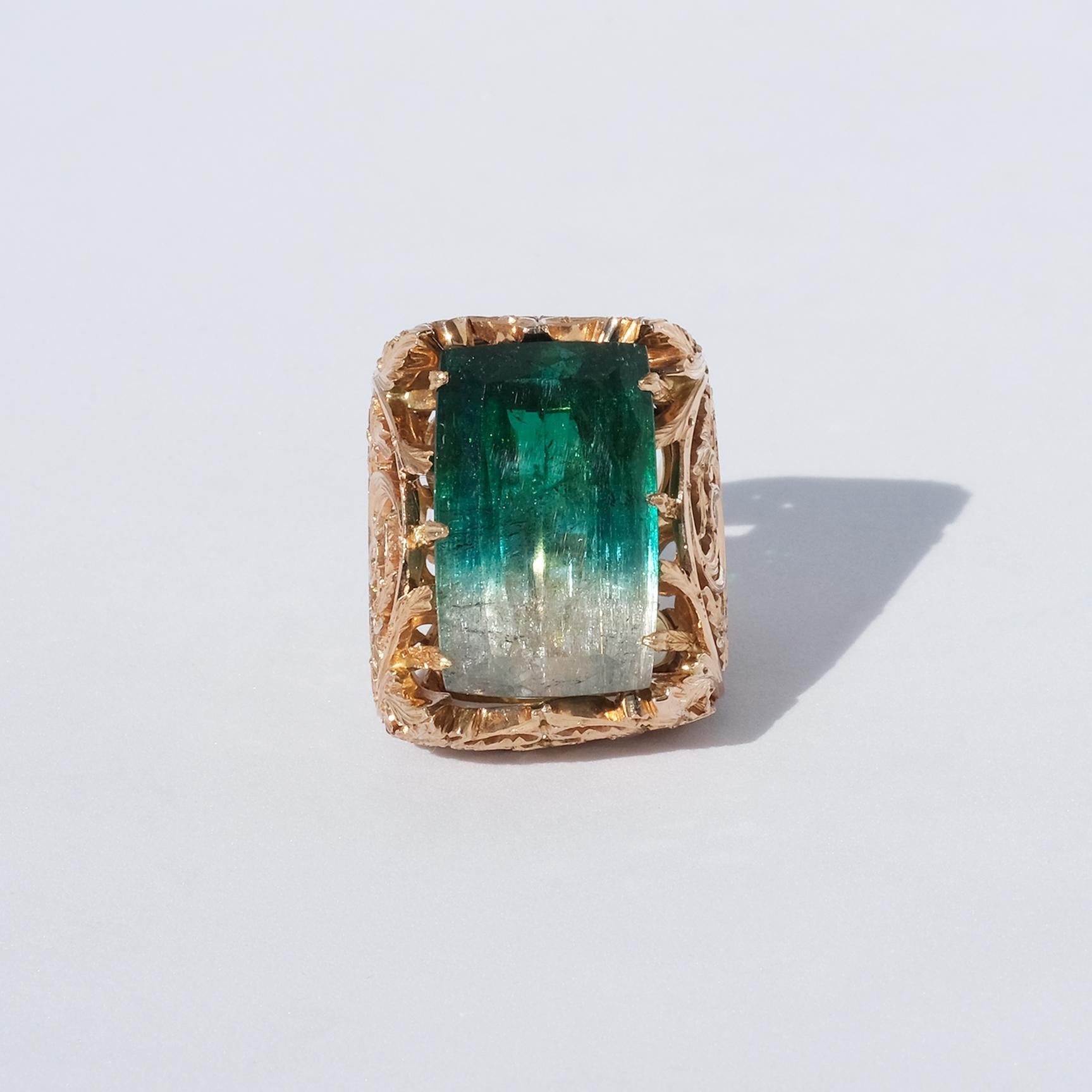 This amazing ring has a large stair-cut tourmaline and its 18 karat setting is adorned with a beautiful rocaille pattern. The quality of the chiseling of this ring is extraordinary.

The unconventional very large size of this ring radiates