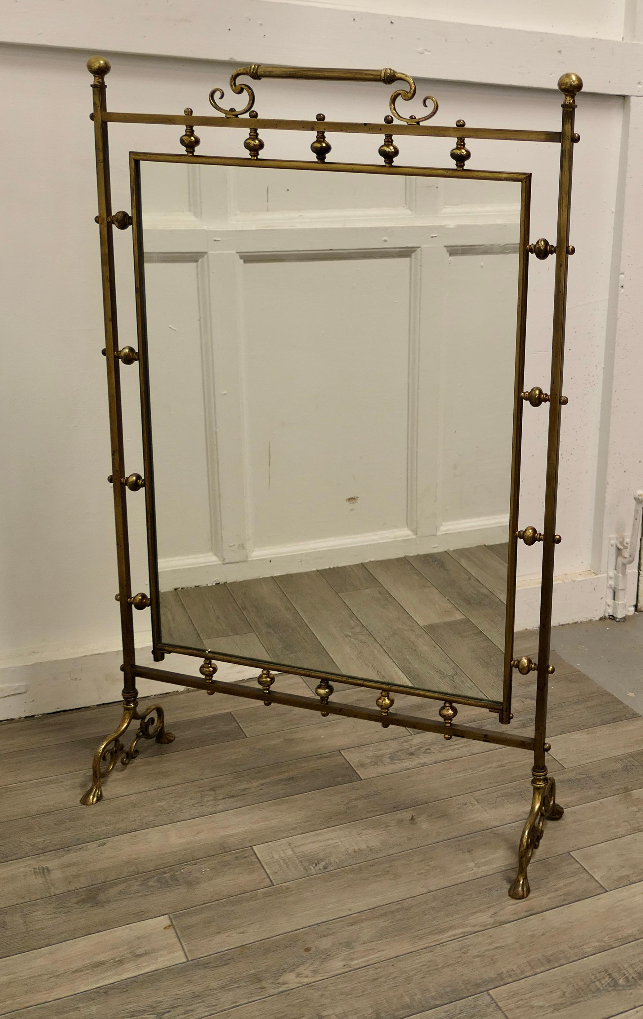A very large Art Nouveau brass mirrored fire screen.

This is a very decorative fire screen it has an ornate brass stand, with a scroll handle and matching feet
The screen is set with a new mirror and it is all in good sound condition, it is