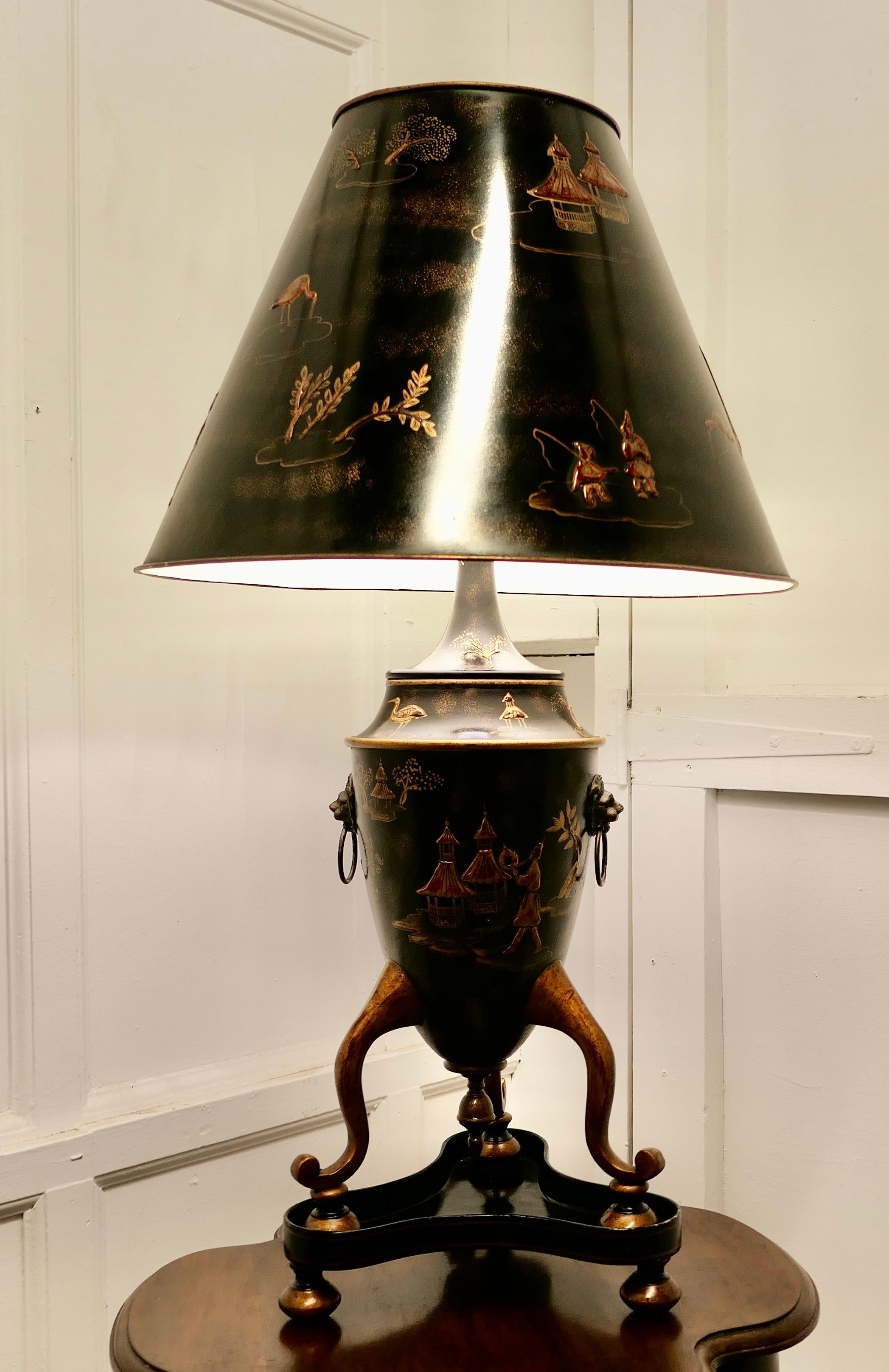 A very large black, gold and red Chinoiserie toleware table lamp 

A large stunning lamp with it’s original shade is in the style of a Georgian Japanese 3 footed urn standing on a Plinth, it has brass mask and ring handles 
Both the lamp and the