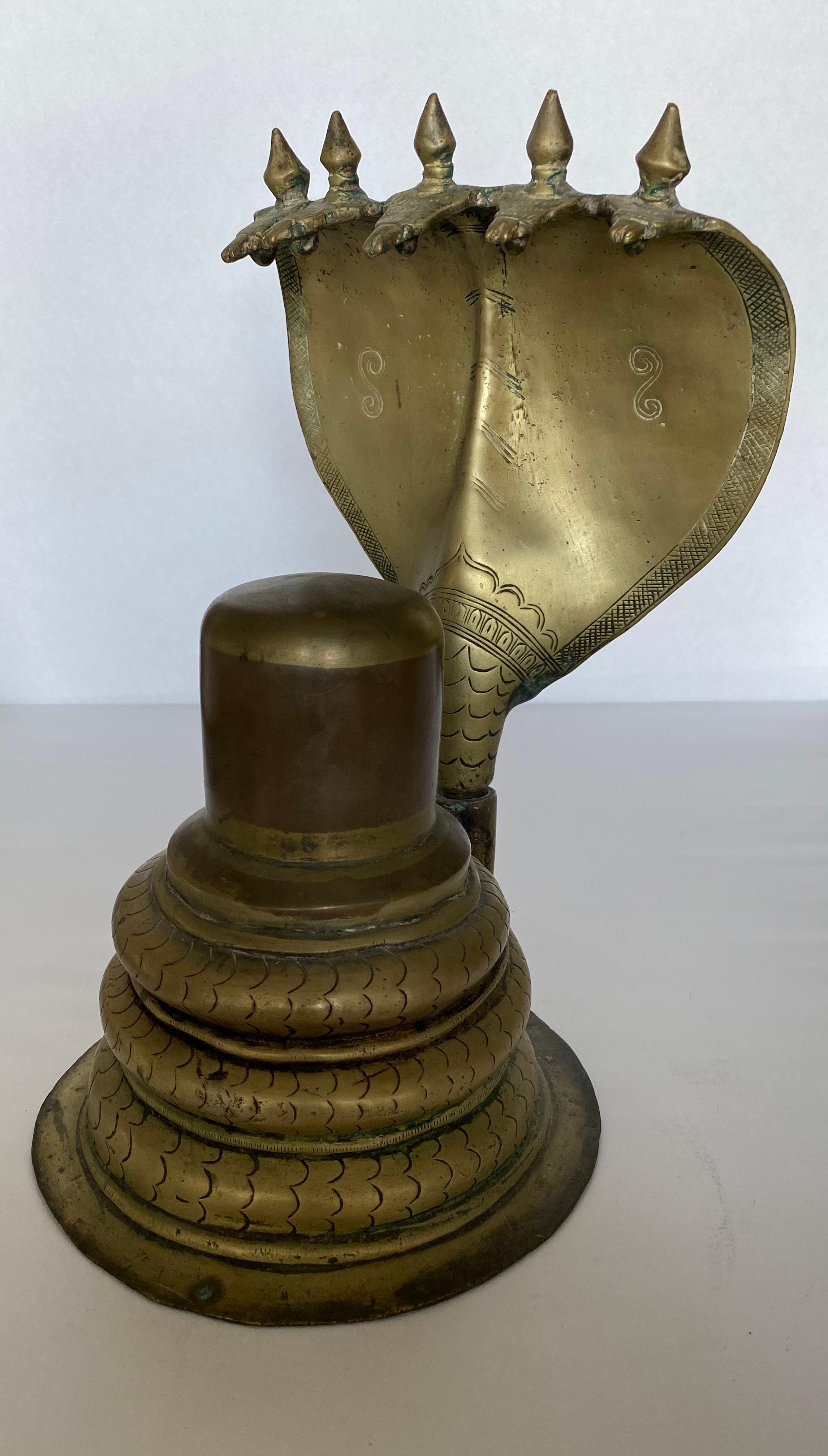 A lingam, sometimes referred to as a linga or Shiva linga, is an abstract or aniconic representation of the Hindu deity Shiva in Shaivism. It is a votary symbol revered in temples or household shrines. In this shrine, cast in 2 sections, the Shiva