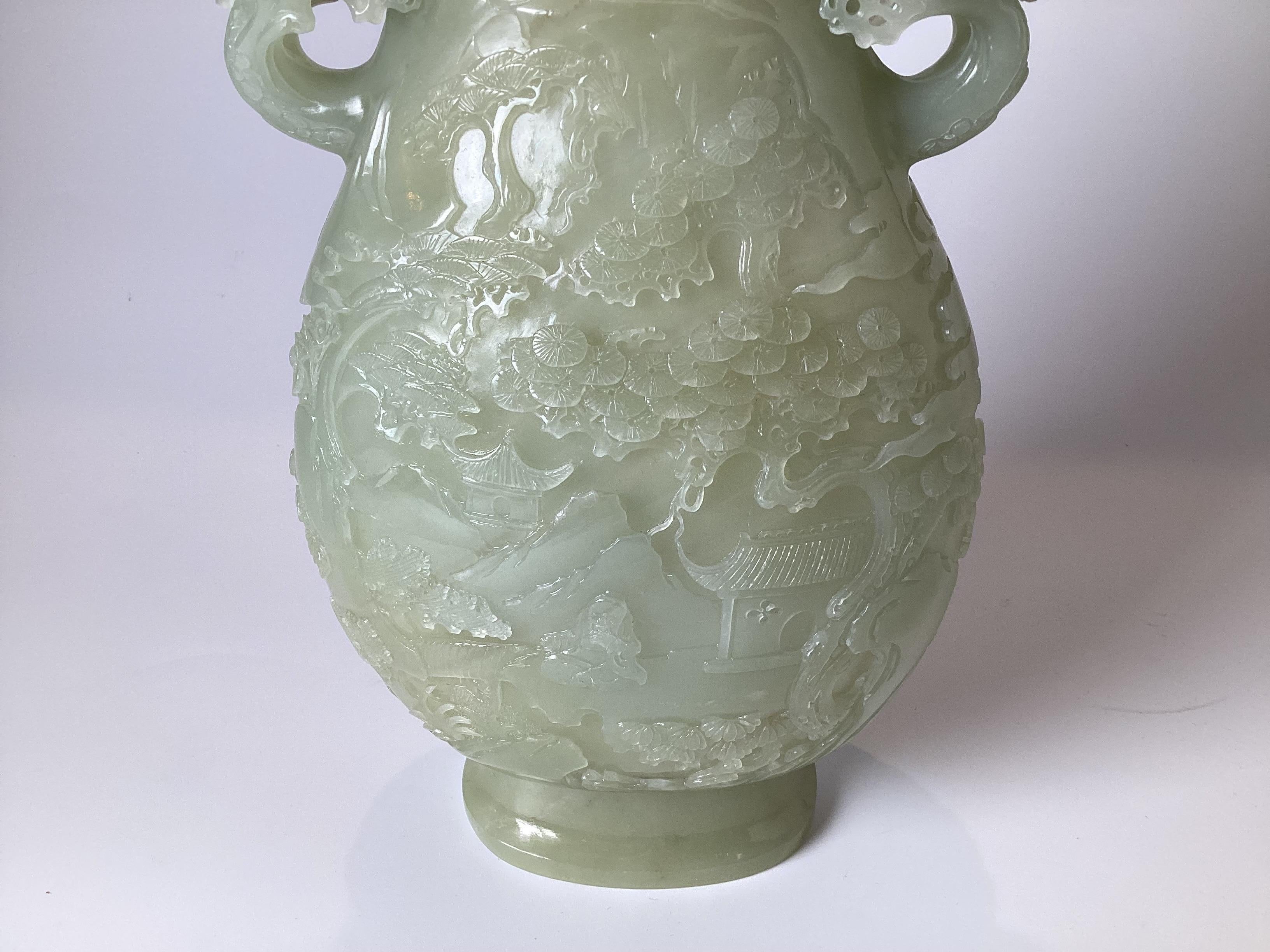 An intricately carve celadon nephrite jade covered vessel. The lid with finial on a slender neck with bulbous botton, with handles on each side.