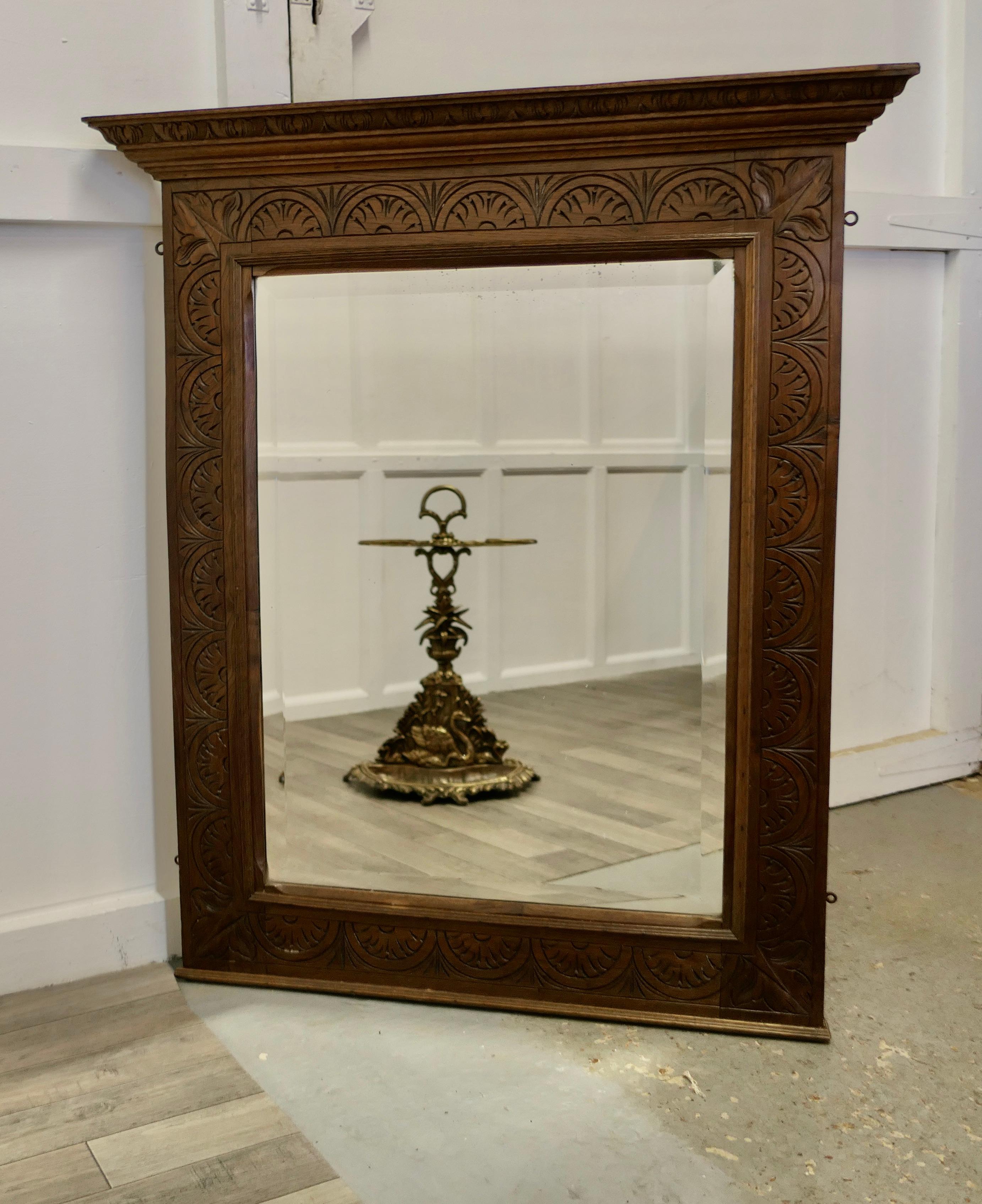 A Very Large Carved Oak Overmantel or Wall Mirror

This is a Large French Mirror the Frame is 5” wide and has a carved decoration matching the carved cornice at the top. The bevelled looking Glass is the original 
The Mirror Frame is 46” high and
