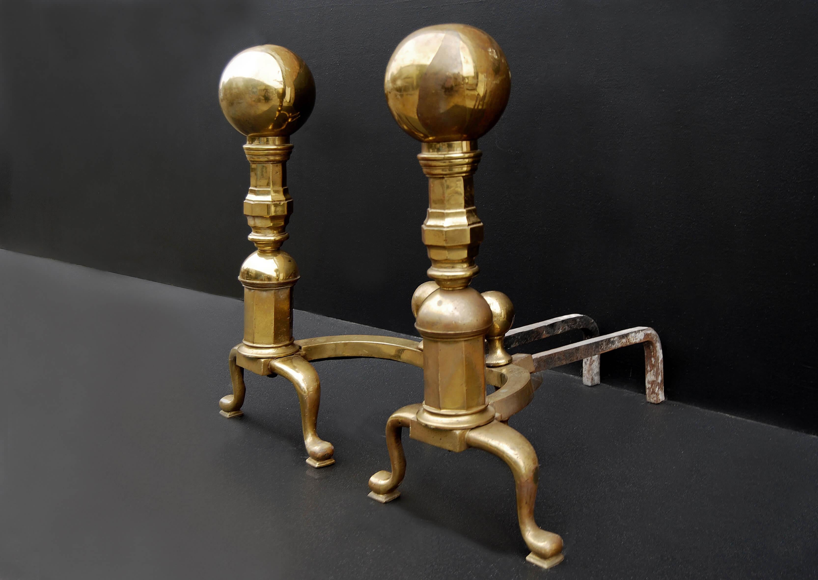 A large and impressive pair of mid 19th century brass firedogs, with cabriole bases, octagonal shaped columns surmounted by large ball tops. Shaped brass returns leading the iron back bars.

Measures: Height: 750 mm 29 ½