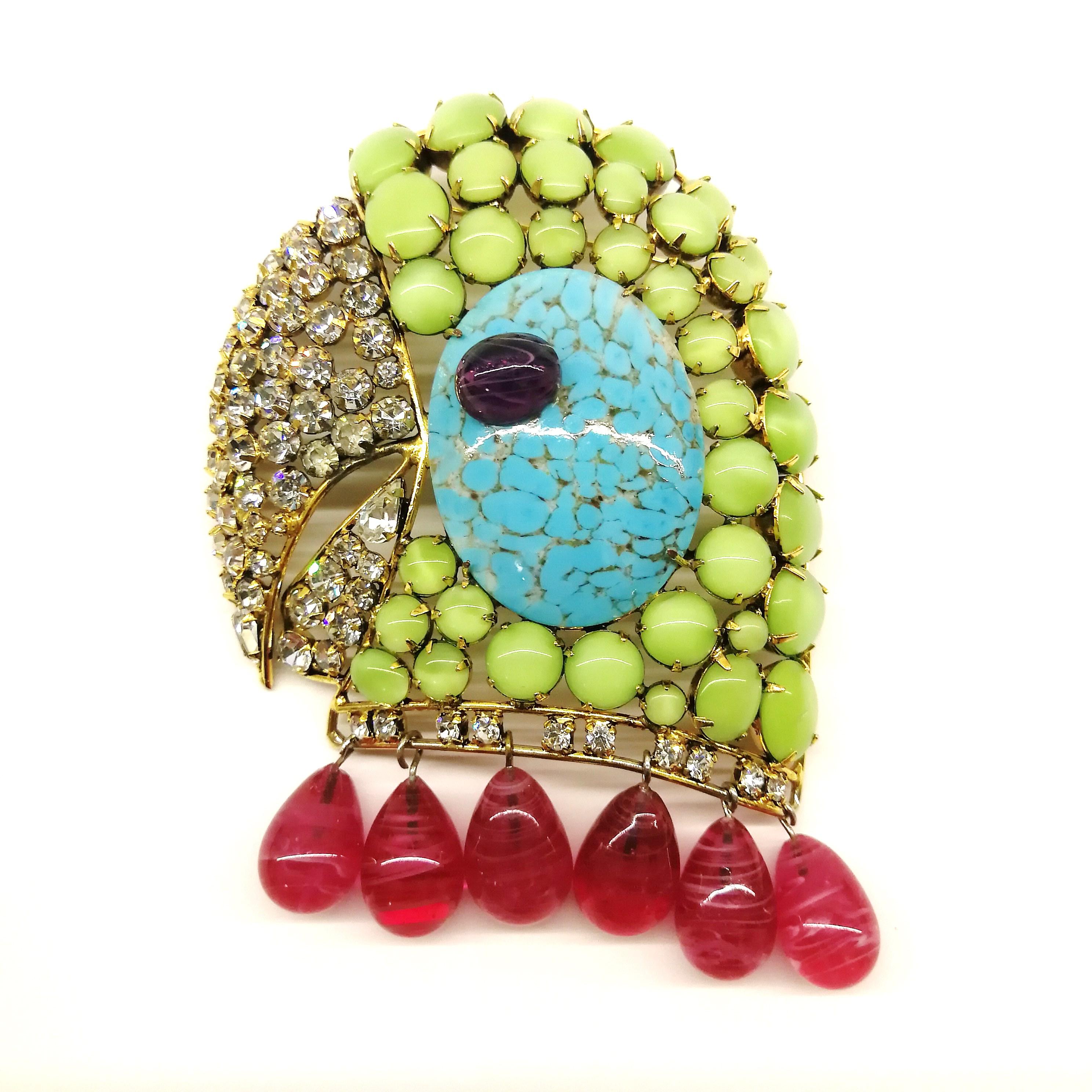 A striking and well known design from Iradj Moini, of a parrot's head, hand made and all stones hand set in 18 carat plated brass. A beautiful combination of colours , as always with this designer - mint green, turquoise, amethyst and ruby, with