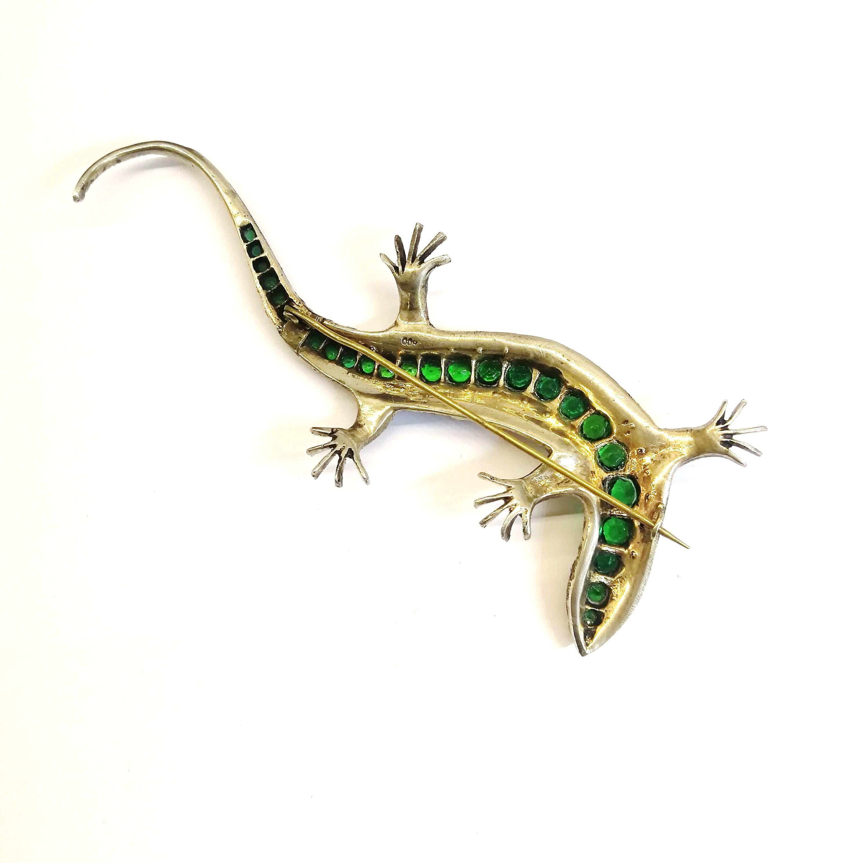 A very large striking sterling silver 'lizard' brooch, in serpentine form, set with old cut emerald and clear pastes, and a ruby paste 'eye', from the early 1900s. it is most probably made in England. It is softly gilded on the reverse, whist the