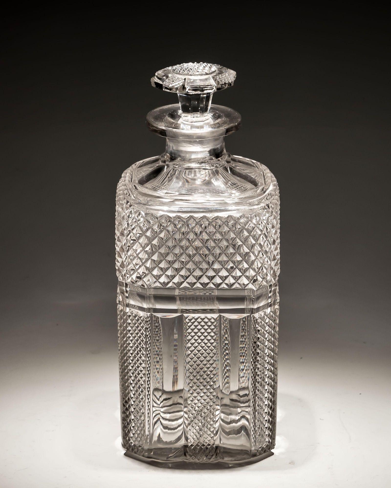 A very large, Regency whiskey decanter with diamond cut panels and corresponding cut stopper.