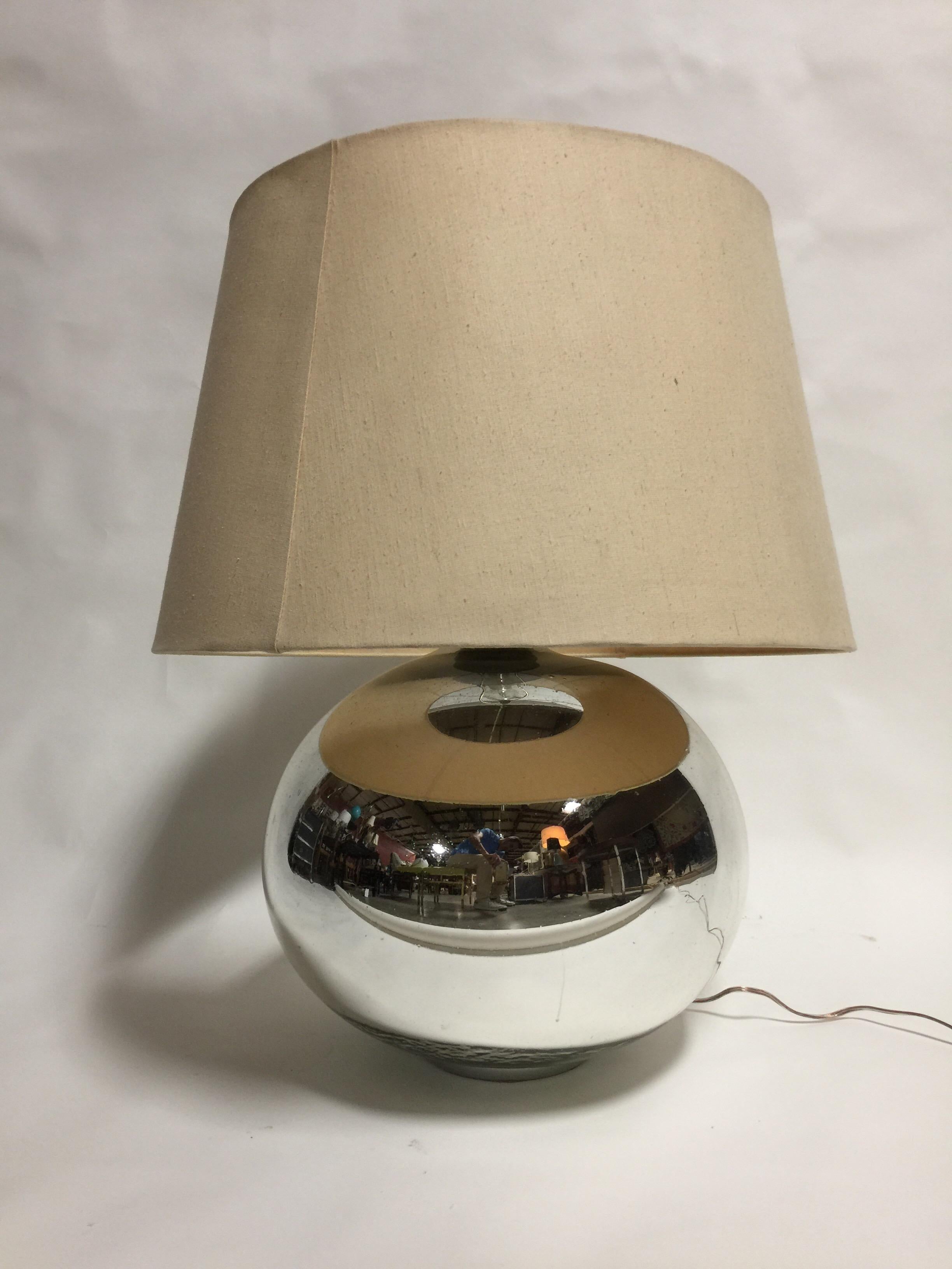 A vintage table lamp with mirrored glass base and cusotm period linen shade. Appears to be mercury glass. USA, circa 1950. Rewired for USA with silk cord; takes one standard US bulb, 100 watts max.

Dimensions: 
Lamp--16 inches W x 17 inches H to