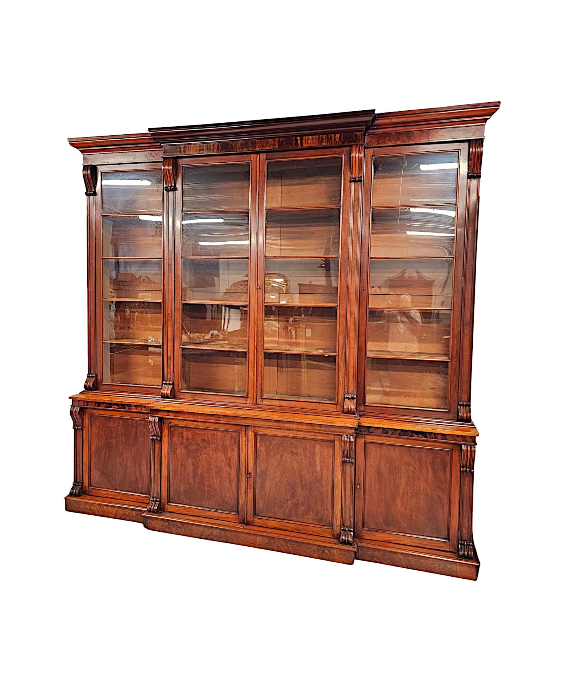 A very rare and impressive 19th Century Irish well figured, flame mahogany four door breakfront bookcase labelled 'Strahan of Dublin', finely hand carved, of grand proportions, exceptional quality and with gorgeously rich patination and fine grain. 