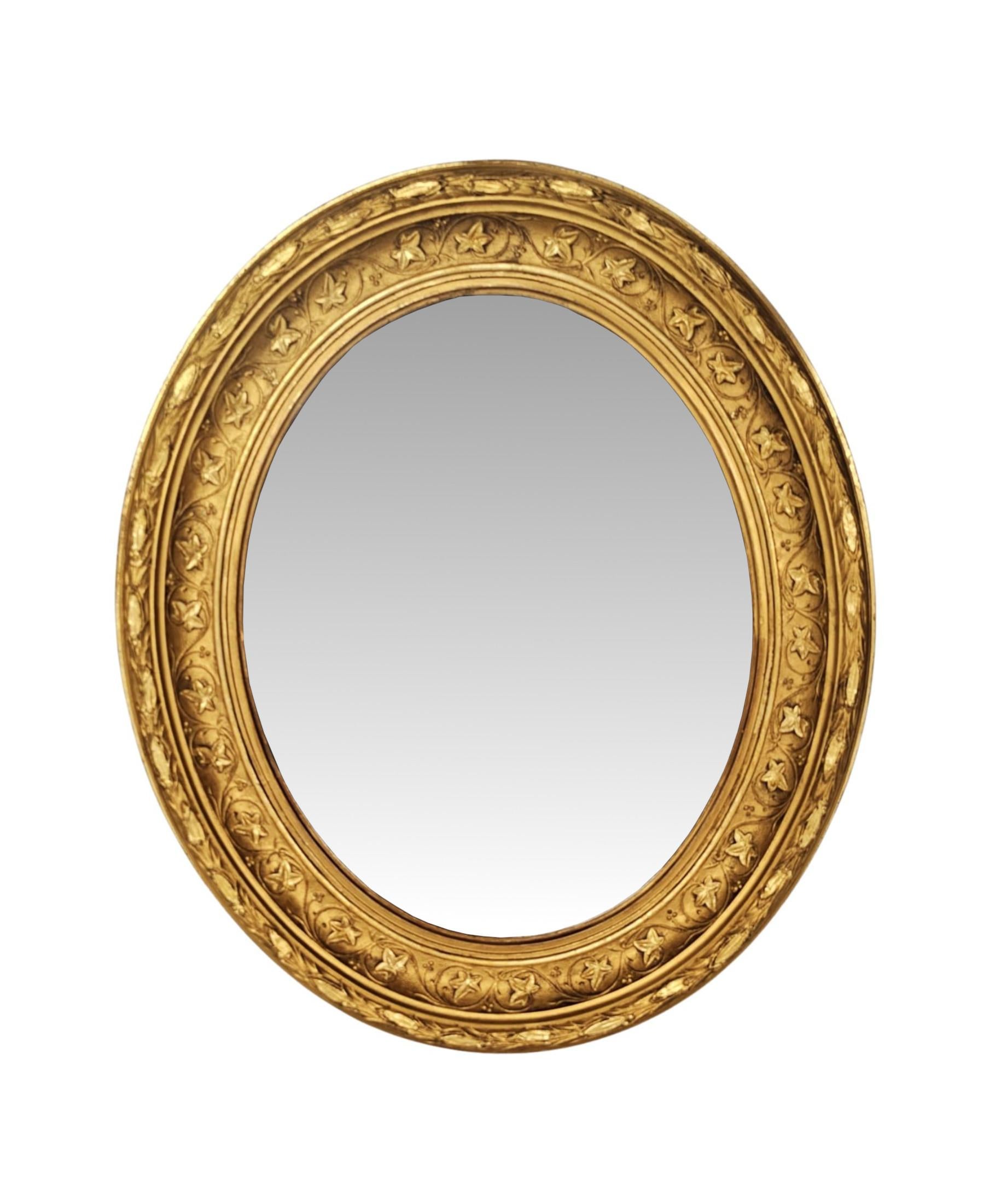 Une paire très rare de miroirs en bois doré finement sculptés à la main au 19e siècle, d'une qualité exceptionnelle.  Les plaques de verre miroir de forme ovale sont enchâssées dans de superbes cadres moulés et cannelés en bois doré avec de
