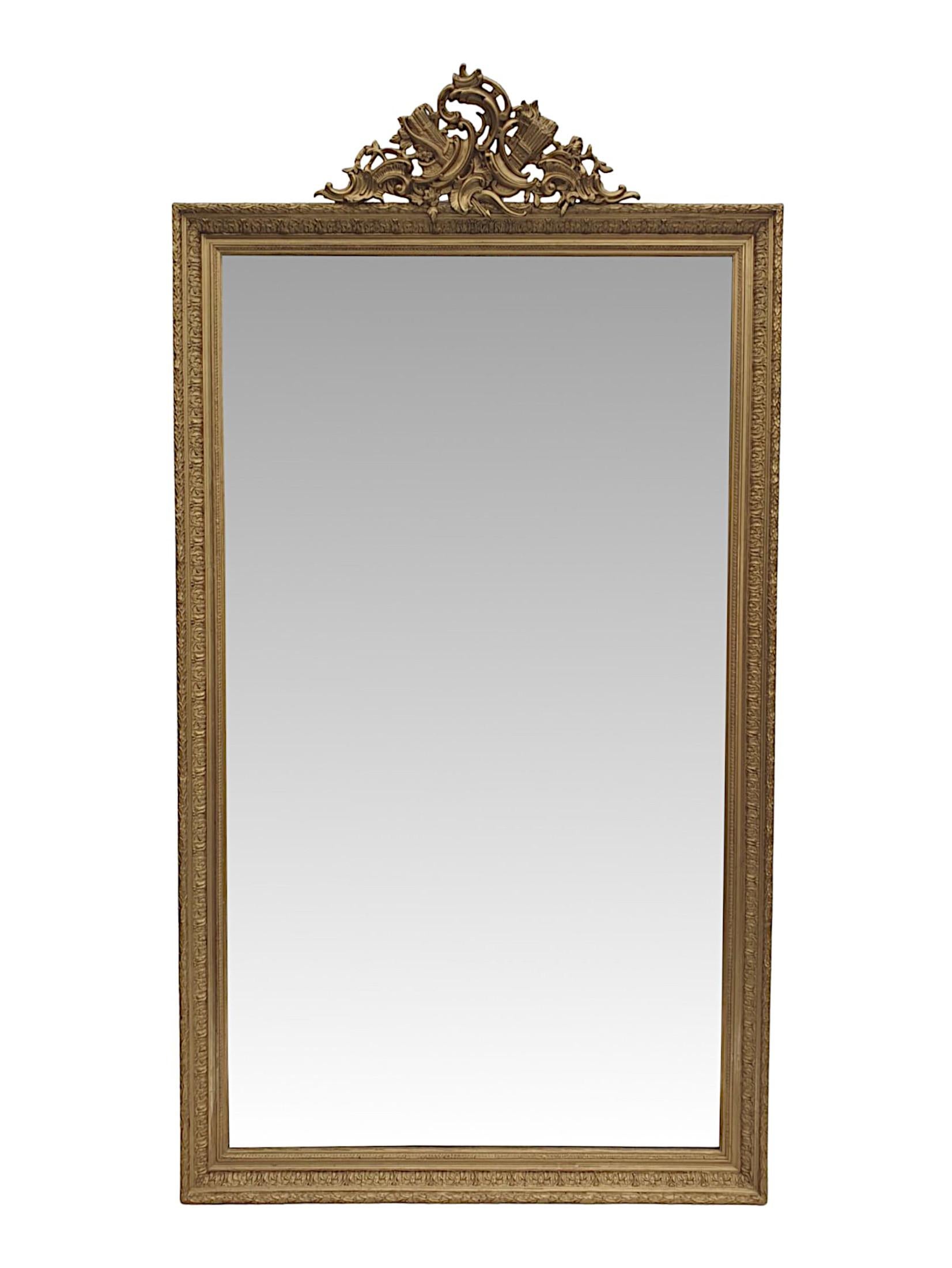 A very rare and fine pair of 19th century overmantle or leaner mirrors of large proportions. The original bevelled mirror glass plate of rectangular form set within a moulded giltwood frame with foliate, flowerhead and leaf motif detail. Surmounted