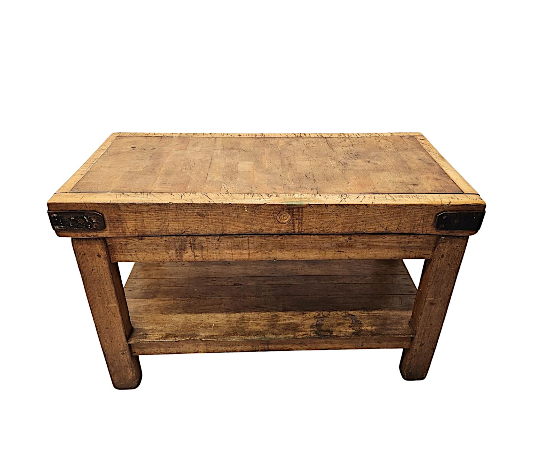 A very rare and impressive 19th Century pine two tiered butchers block table of exceptional quality, large proportions and finely hand carved with rich patination and grain.  The finely figured moulded, panelled and iron bound top of rectangular