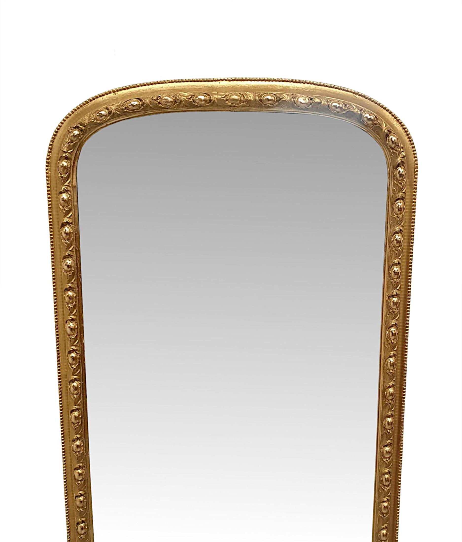 Un très rare et fin miroir de coiffeuse ou de jetée en bois doré du XIXe siècle, d'une qualité exceptionnelle et aux proportions à la fois hautes et étroites.  La plaque de verre miroir est enchâssée dans un cadre en bois doré finement sculpté à la