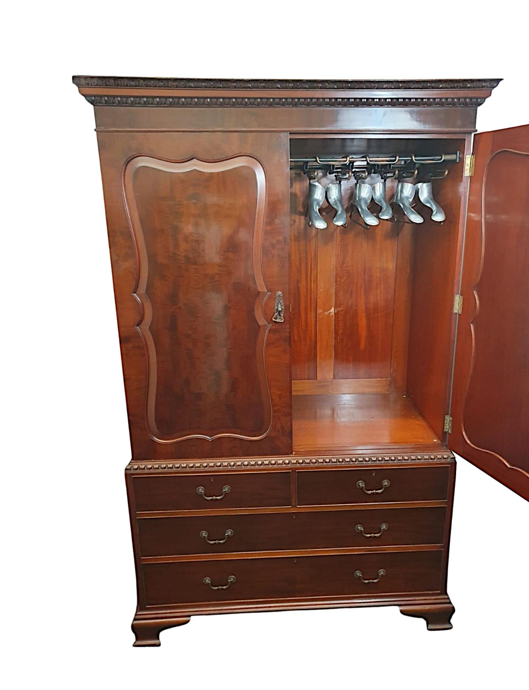 A very rare Edwardian gentleman's plum pudding and flame mahogany wardrobe with chest base. The stepped cavetto pediment with intricately hand carved egg and dart motif raised over two doors with beautifully shaped panels of stylised rectangular