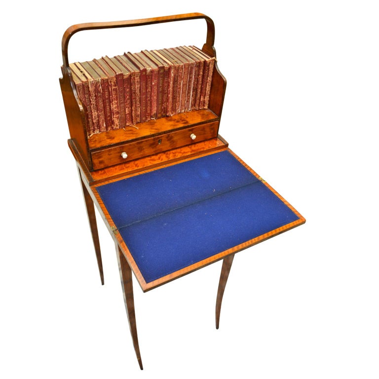 An elegant Bonheur du jour, (cheveret table), of the highest quality. The table is veneered in golden satinwood banded with tulipwood and boxwood. The book tray with an incorporated handle has curved side and back panels with a drawer underneath.