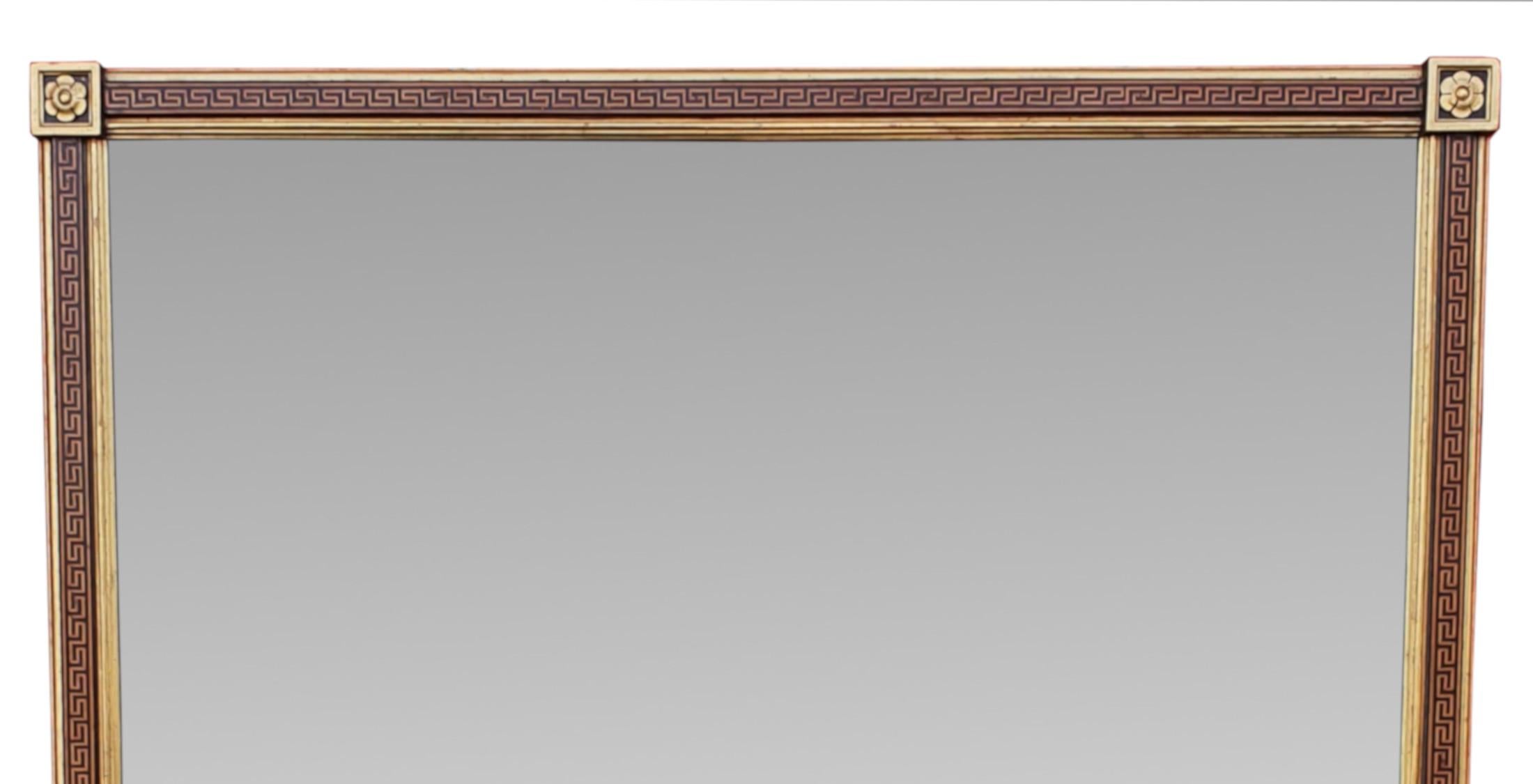 A very rare large size 19th Century giltwood overmantle mirror. The mirror plate of rectangular form set within a stunningly carved giltwood and ebonised frame with Neoclassical greek key carving and with applied flower head and s-scroll motif