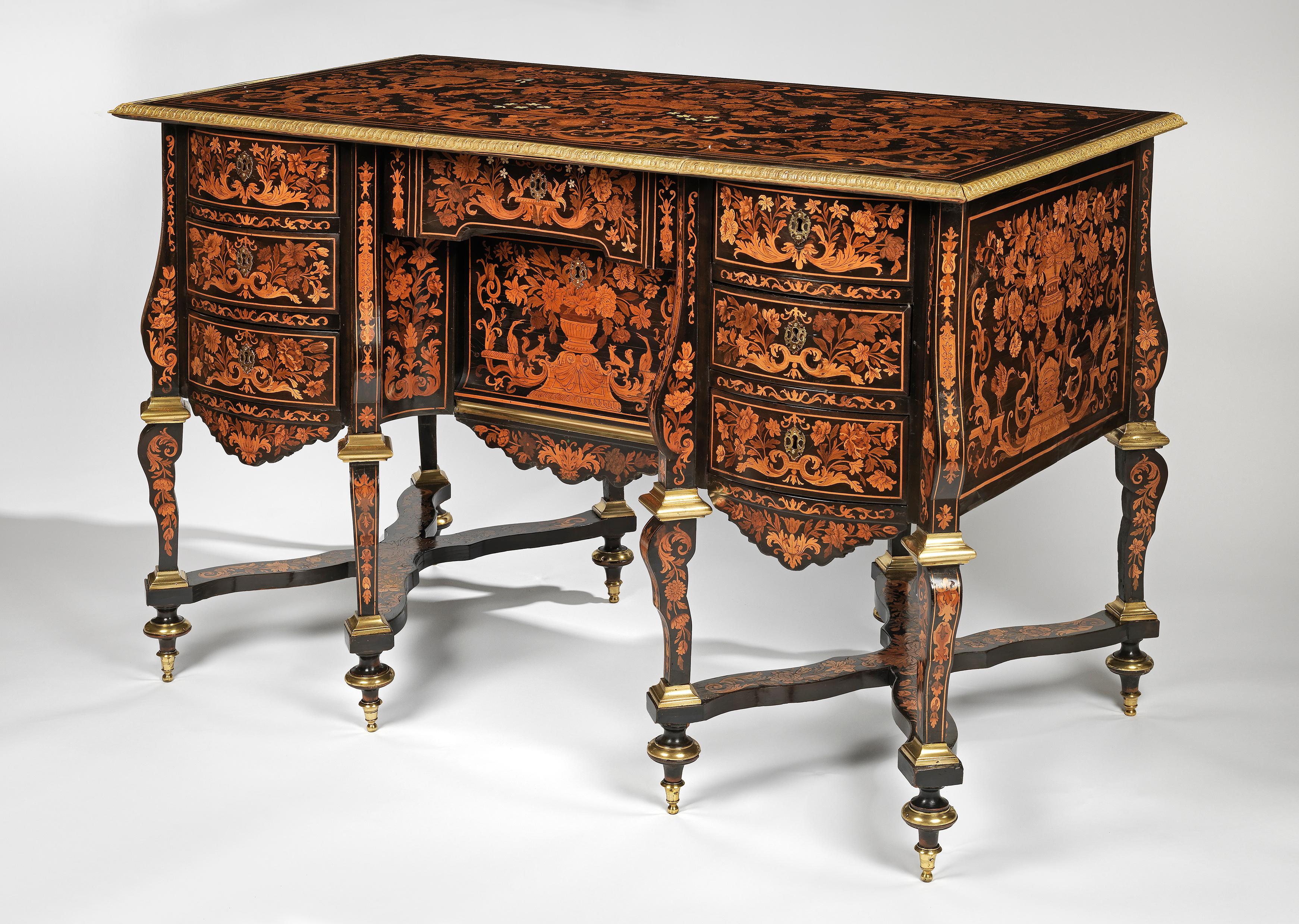 This rectangular bureau inlaid with floral marquetry is raised on eight curved legs of rectangular section, which are connected by two flat, interlaced stretchers. In the middle of the front is a recessed drawer, and to either side are tiers of