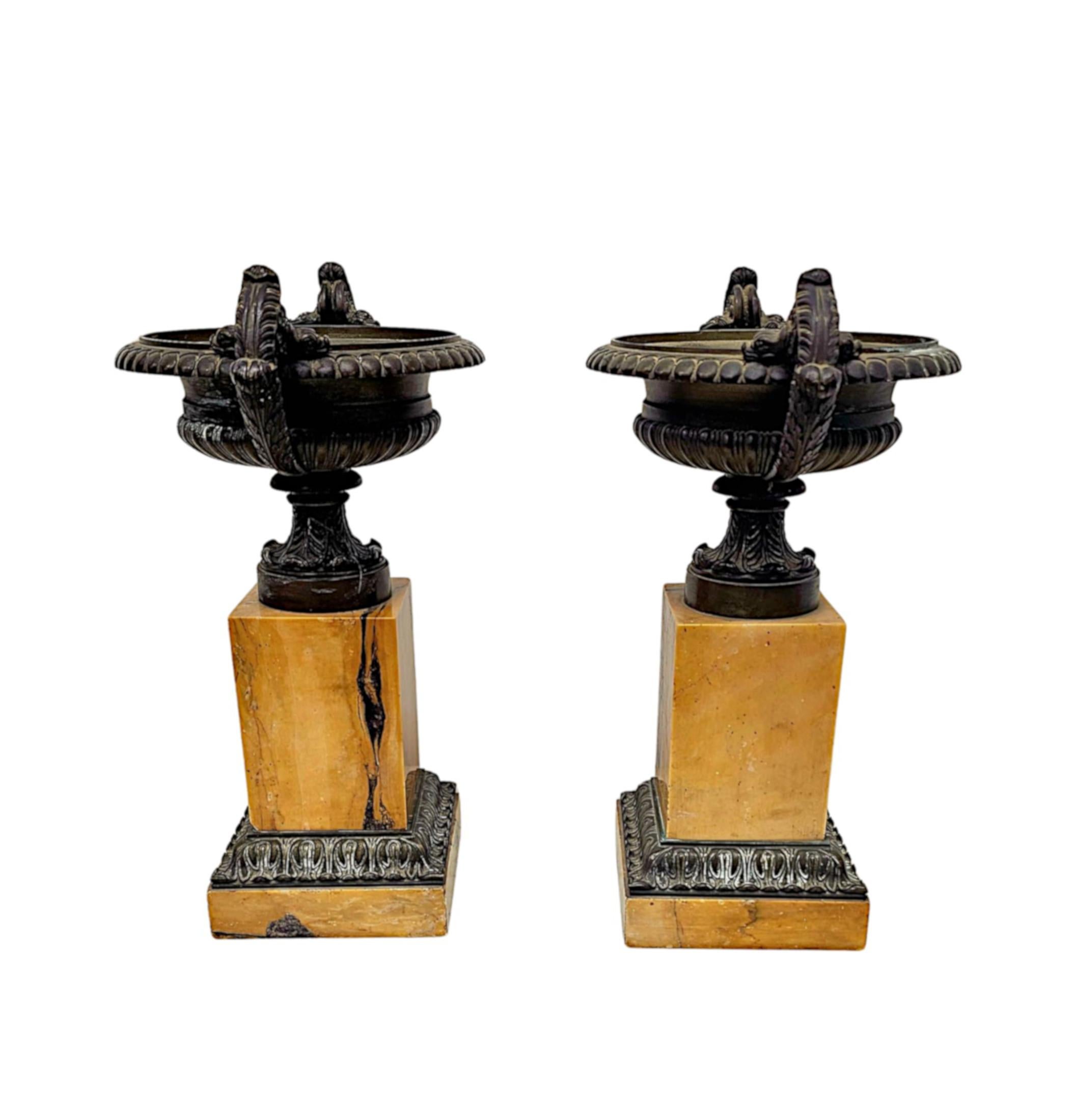 Una rarissima coppia di urne da tazza in bronzo finemente fuse del XIX secolo, di qualità eccezionale e di grandiose proporzioni.  Le urne di forma circolare con motivi decorativi a sfera sul bordo estroflesso e dettagli a gadroon sul corpo sopra