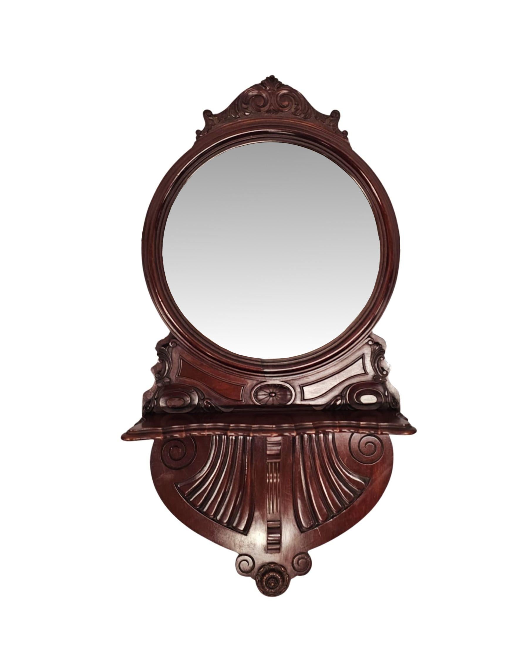 Une paire très rare de miroirs en acajou du 20e siècle d'une qualité exceptionnelle, finement sculptés à la main avec une patine riche et un grain fin.  La plaque de verre biseautée de forme A est enchâssée dans un superbe cadre en acajou mouluré et