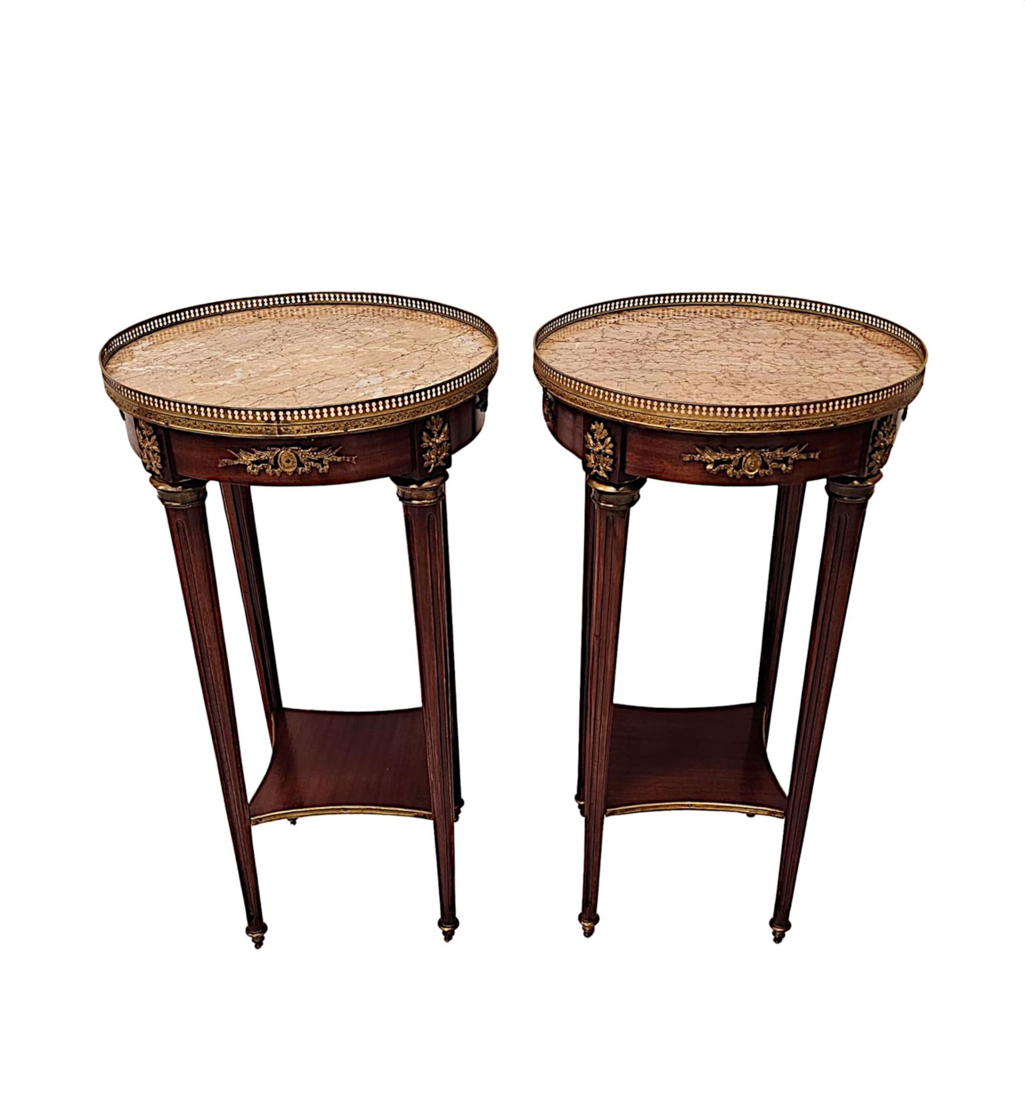 A very rare pair of early 20th Century finely carved well figured mahogany marble top lamp or side tables of exceptional quality, with rich patination, grain and ormolu mounted throughout.  The gorgeous moulded Emperador marble top of circular form