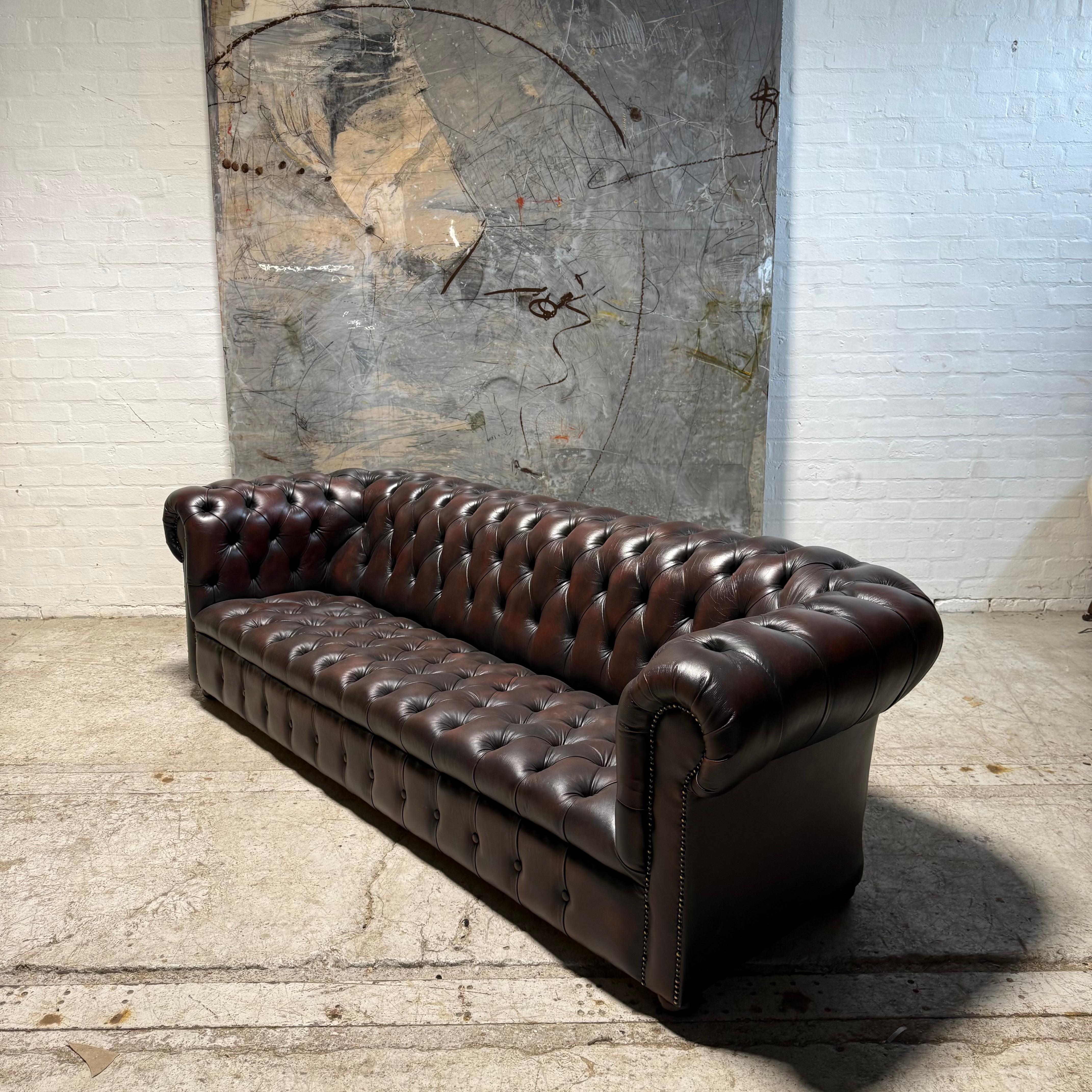Pelle Un elegante divano a 4 posti Chesterfield in pelle della fine del XX secolo - marrone scuro in vendita