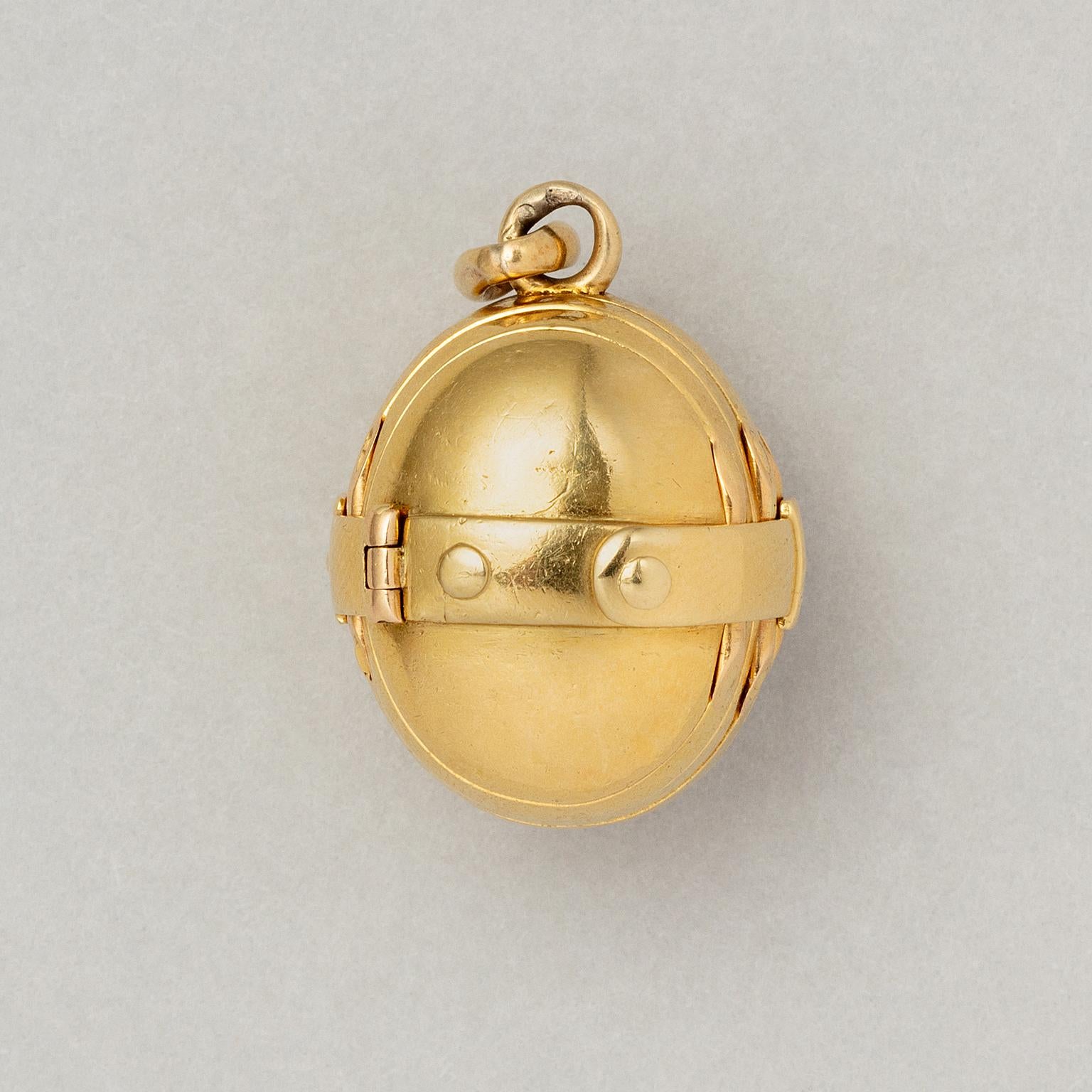 A chunky 18 carat yellow gold egg shaped locket hugged by a classical belt. If you open the belt the egg unfolds itself in to six small oval lockets that each can hold a small picture. The cute locket can be hung on a chain, to close the locket you