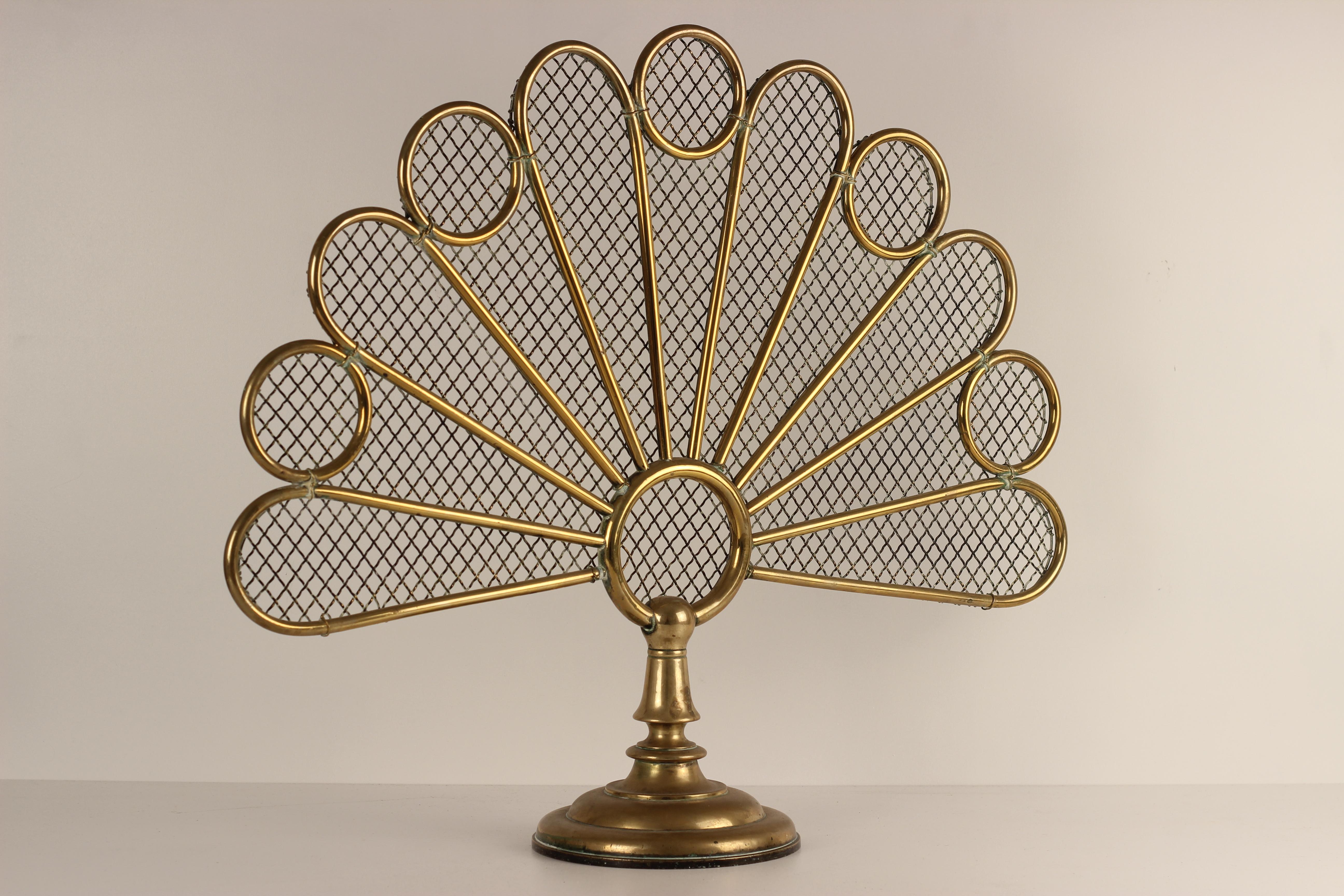 An unusual Victorian Aesthetic movement Brass Spark guard or Fire Guard modelled on a simplified motif of a Peacock Tail. The Aesthetic Movement was influenced heavily by the stylised renditions of China and Japan, and referenced it through many