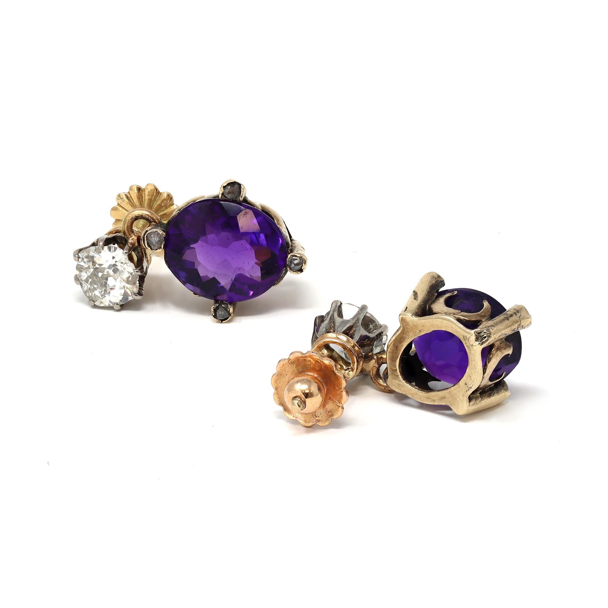 An original pair of Victorian earrings circa 1890 featuring diamond studs and vibrant purple oval amethysts dangle. The diamonds are old mine cut and have an estimated weight of one carat, HI color SI clarity. The amethysts are oval shape and