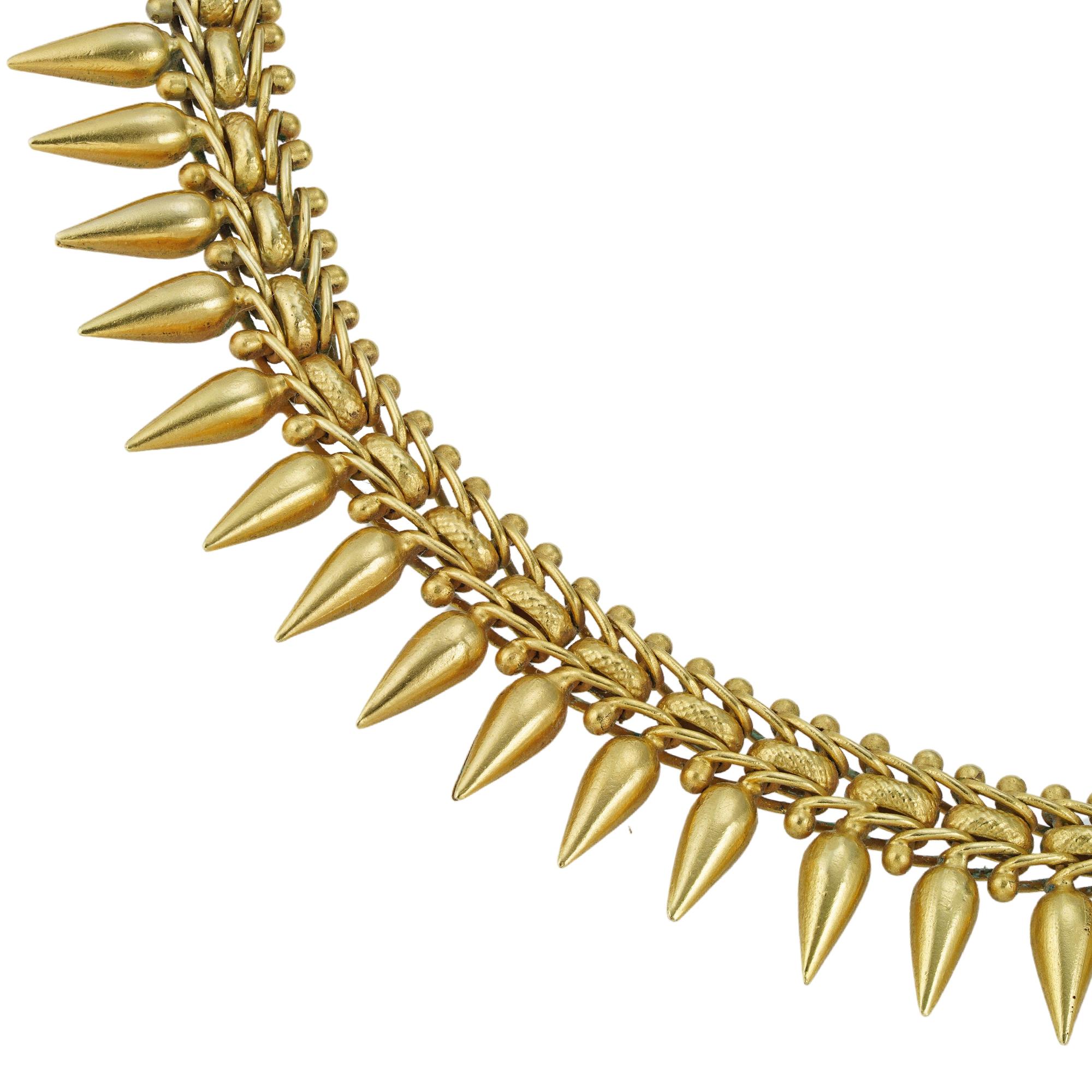 A Victorian archaeological revival gold necklace, consisting of a row of fancy links, suspending eighty-six cone-shaped drop motifs, all made in yellow gold, with pull-down ring clasp, circa 1870, measuring approximately 44 x 1.5cm, gross weight