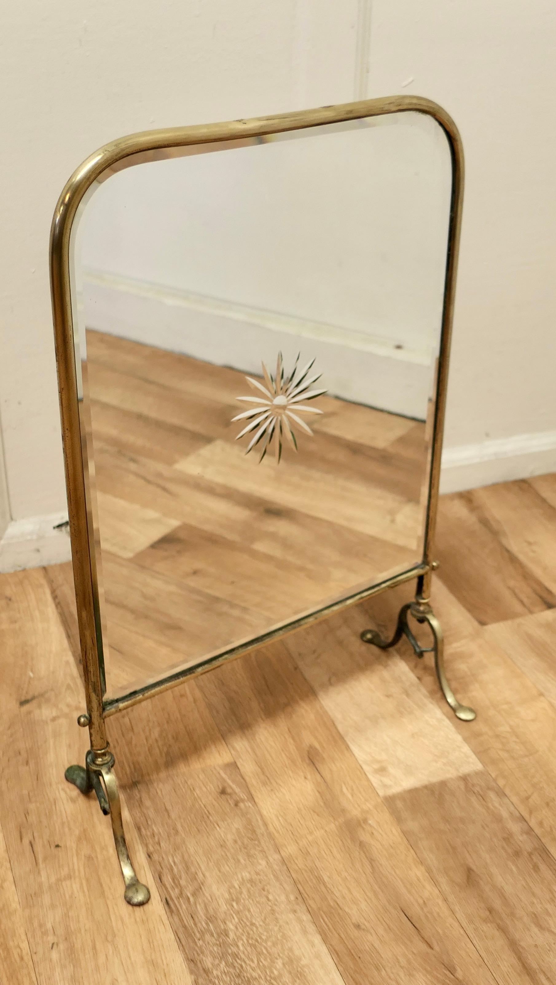 A Victorian Art Nouveau Brass and Sunburst mirror Fire Screen

This is a decorative Fire Screen it has a brass frame and stand, the bevelled Mirror has an etched Starburst in the centre
The screen is in fair used condition, there is some hazy