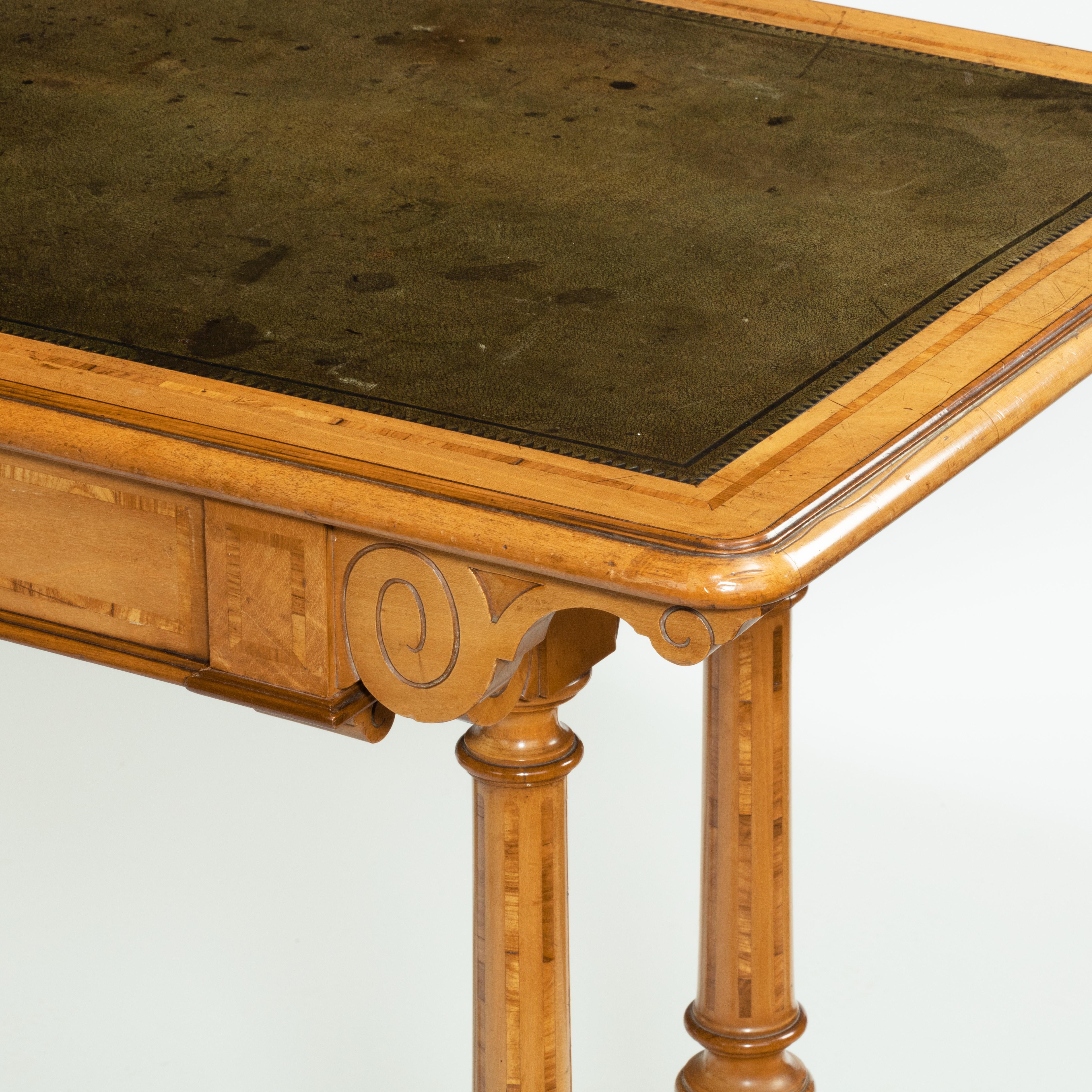 A Victorian birch or satinwood writing table, attributed to Holland and Sons, the leather-inset top with moulded edges above a disguised single frieze drawer, the end supports comprising twin turned columns set on splayed square section legs joined