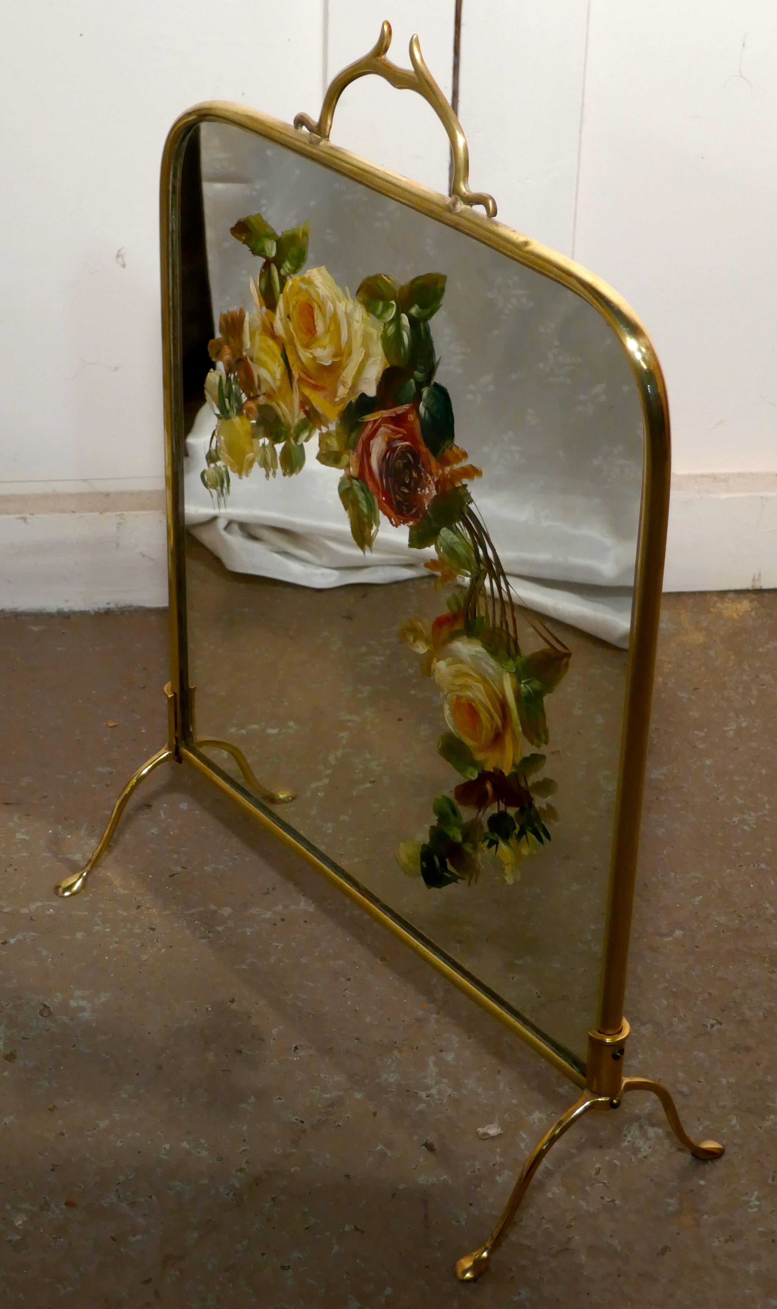 A Victorian brass and roses painted mirror fire screen

This is a most decorative fire screen it has a brass stand, the mirror is painted with large colorful roses.
The screen is in good sound condition, but there is a very little wear of the