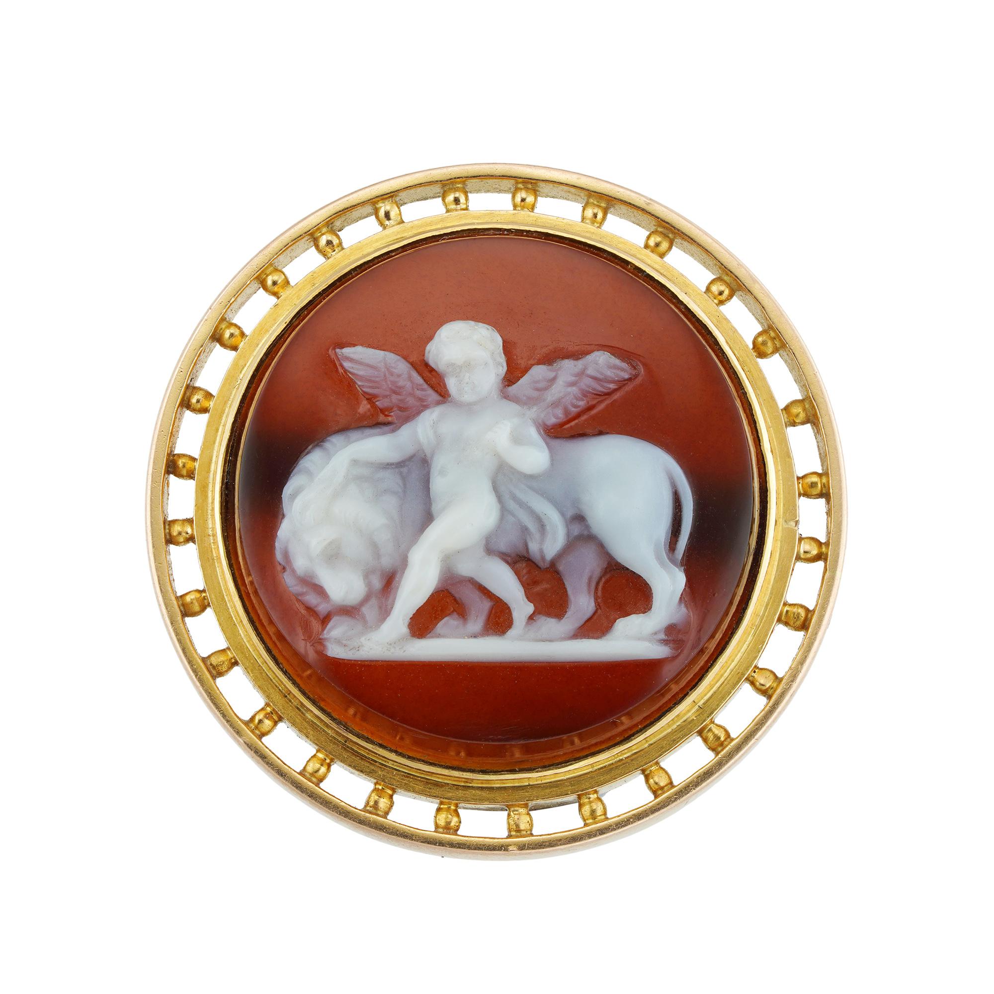 A Victorian carved hardstone cameo brooch, the circular carved hardstone depicting Eros accompanied by a lion, surrounded by yellow gold frame with beaded openwork border, circa 1870, measuring approximately 2.7cm in diameter, gross weight 9.2