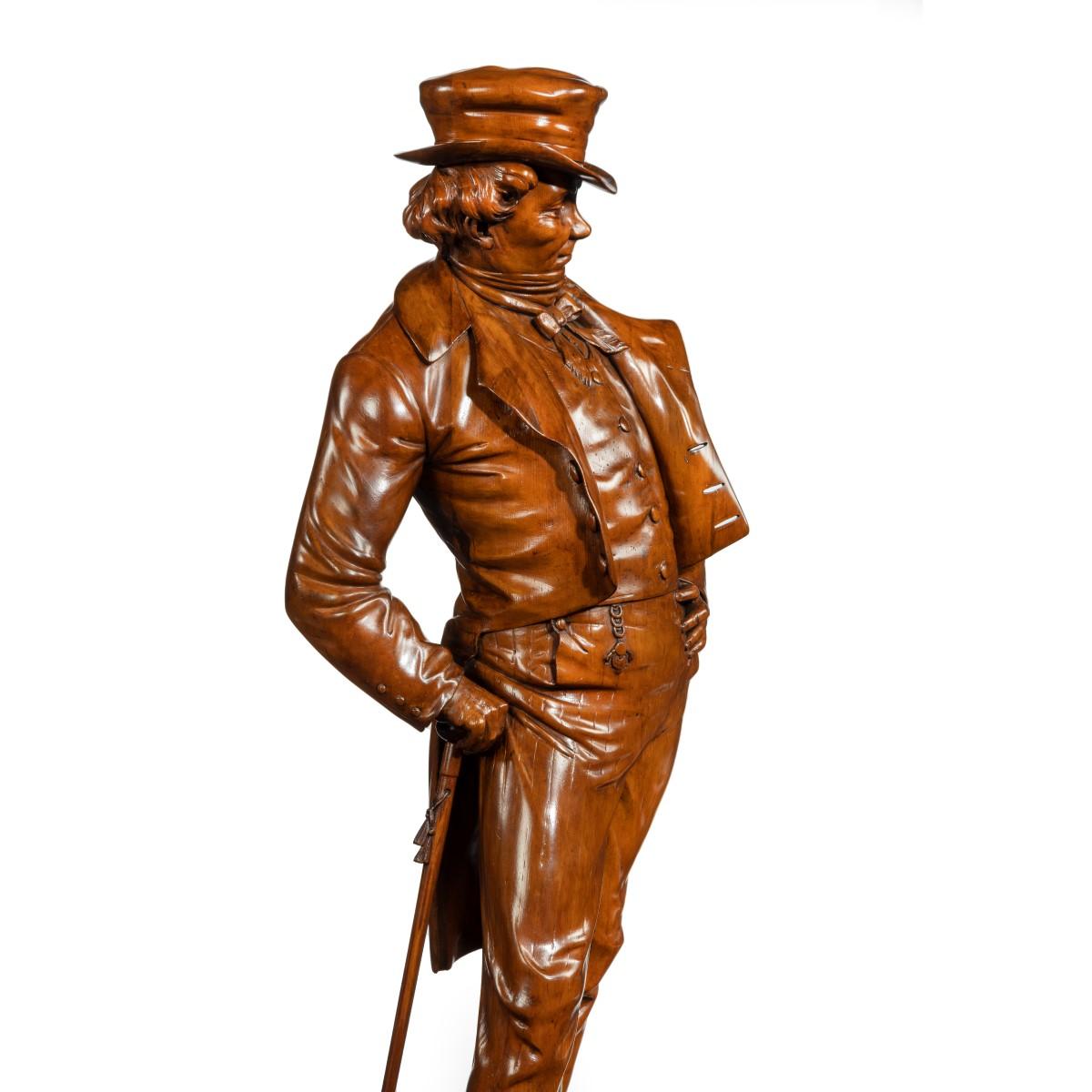 Figure victorienne en noyer sculpté d'un gentleman à la mode, portant un chapeau haut de forme, une queue de pie et un gilet boutonné, prenant une pose nonchalante avec une main sur la hanche, se soutenant sur sa canne à glands, le tout reposant sur