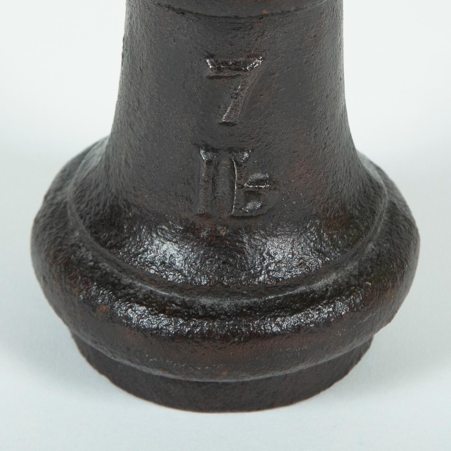 A Victorian cast iron 7 lbs standard bell weight. 

Ex. County of Monmouth.