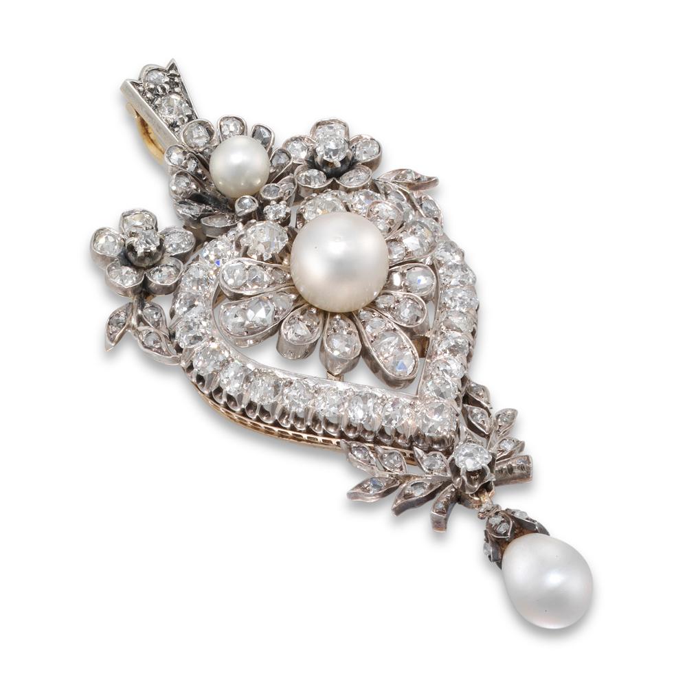 A Victorian diamond and pearl pendant, the central pearl within a diamond heart surmounted by floral motif in pearl and diamond, a pearl drop to base suspended by diamond foliate decoration, convertible to a brooch, the diamond set in silver and