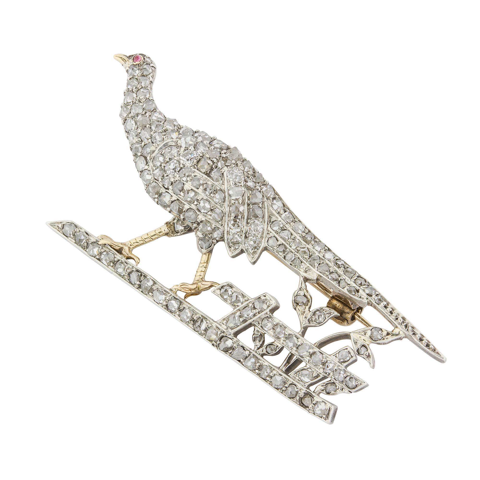 A Victorian diamond set pheasant brooch, pave set with rose diamond with a cabochon ruby eye, standing on a base with fence and foliate detail, the diamonds set in silver and mounted on yellow gold, circa 1880, measuring 4.9 x 2cm, gross weight 5.4