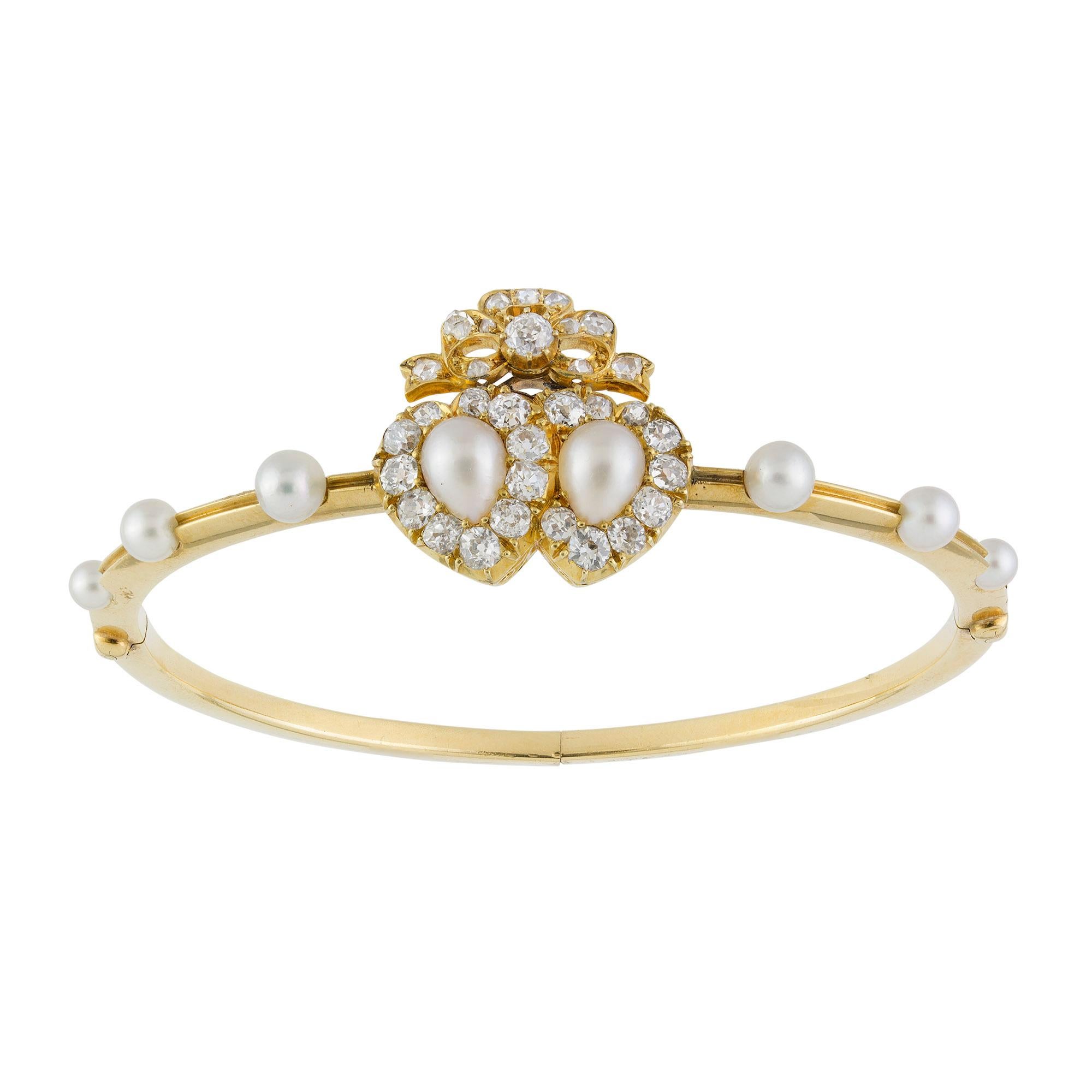 Braccialetto vittoriano con doppio cuore di diamanti e perle naturali, con due cuori intrecciati al centro e una perla incastonata, sormontati da un fiocco di diamanti taglio rosa e un braccialetto con tre perle incastonate su entrambi i lati, tutto