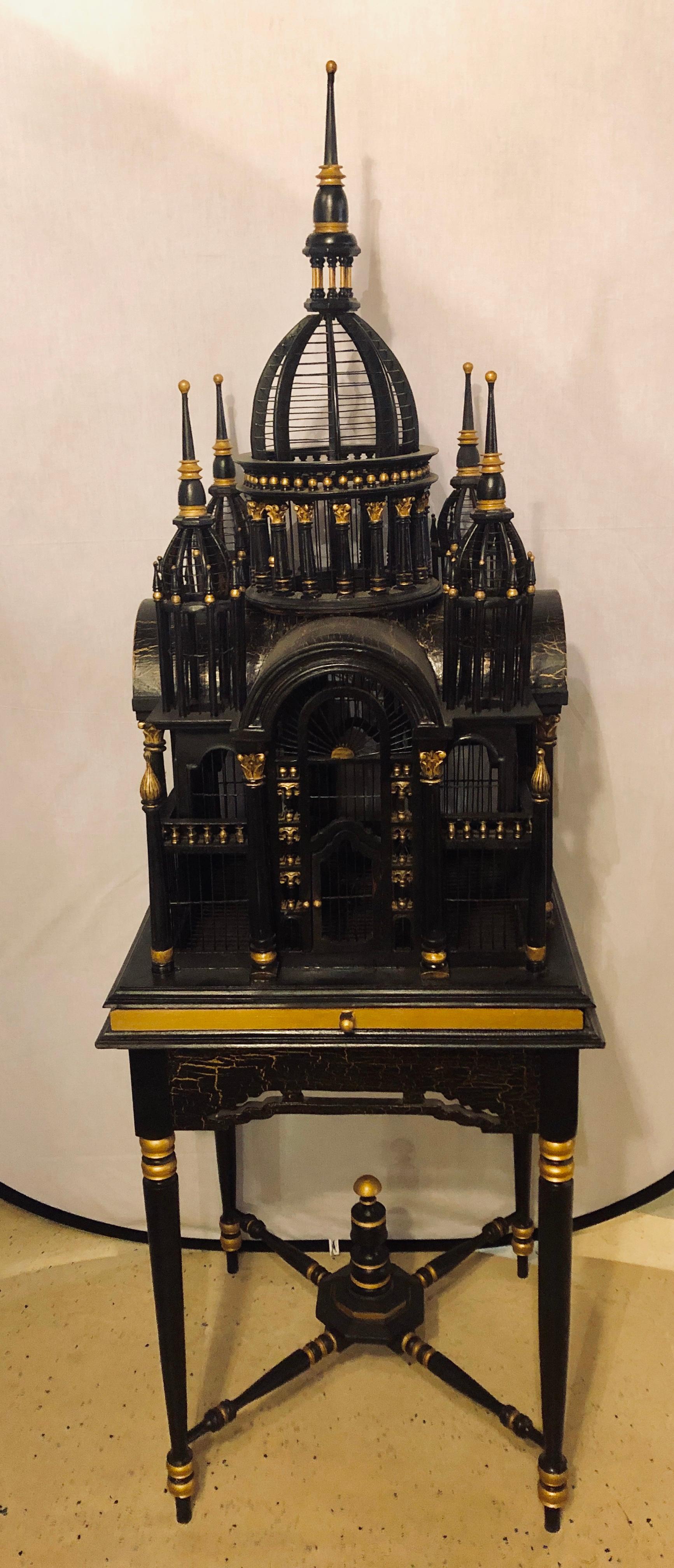 A Victorian ebony and gilt faux marble decorated birdcage on a stand. This functional birdcage has a lower sliding plate to clean the debris and a wide upon interior to allow room for a large bird. The top cage area removed from the lower pedestal