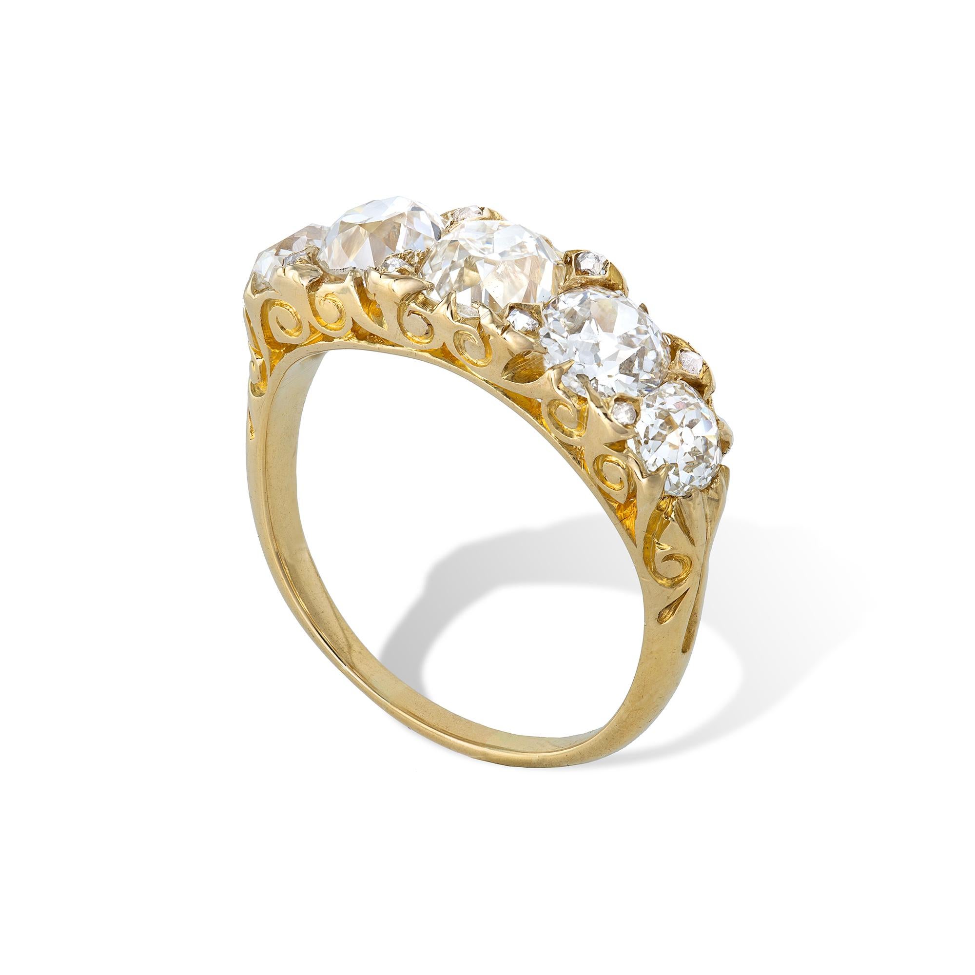 A Victorian five-stone diamond ring, the carved half hoop ring with five old brilliant-cut diamonds weighing approximately a total of 4.75 carats, with rose-cut diamonds set in-between, all claw-set to a yellow gold mount with scrolled shoulders,