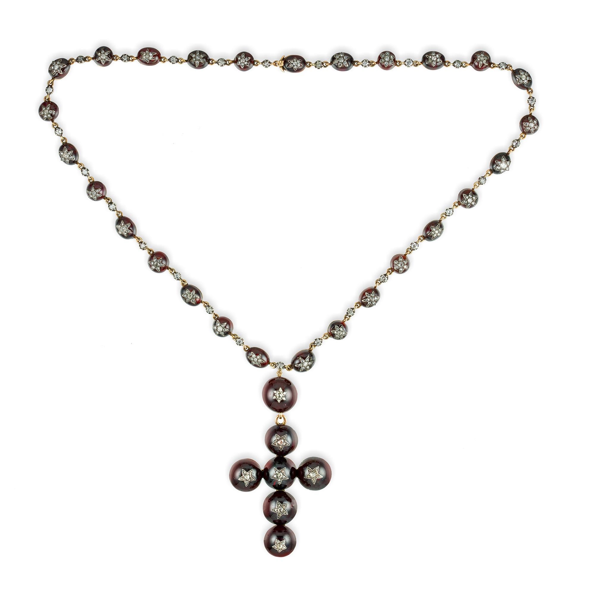 A Victorian garnet and diamond cross necklace, the cross pendant consisted of six circular cabochon garnets applyed with old- and rose-cut diamond-set stars to the centres, suspended from a larger circular top of similar design, all attached to a