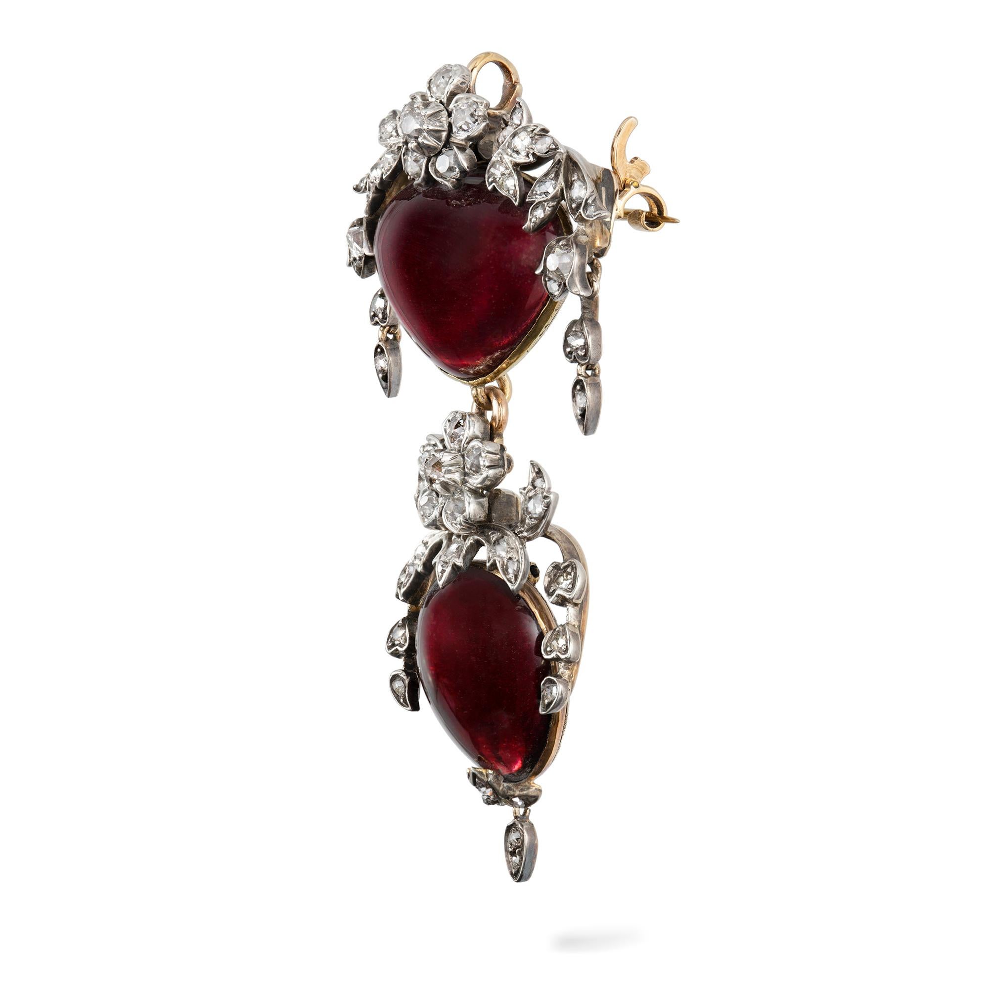 A Victorian garnet and diamond pendant/brooch, the heart shaped cabochon garnet surmounted by a floral and foliate spray, set throughout with rose-cut, old brilliant-cut and cushion cut-diamonds, to a delicately etched gold closed back setting with