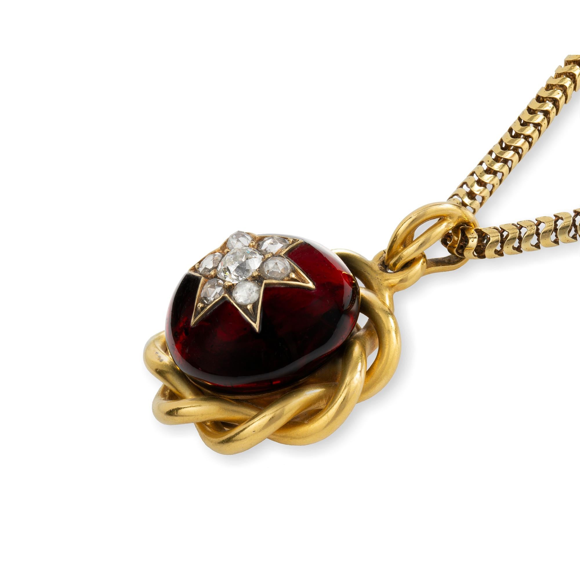 Ciondolo vittoriano con granato e diamante, con stella di diamante vecchio taglio brillante incastonata al centro di un granato rotondo taglio cabochon, all'interno di una cornice d'oro intrecciata sormontata da un anello pendente a filo ritorto; il