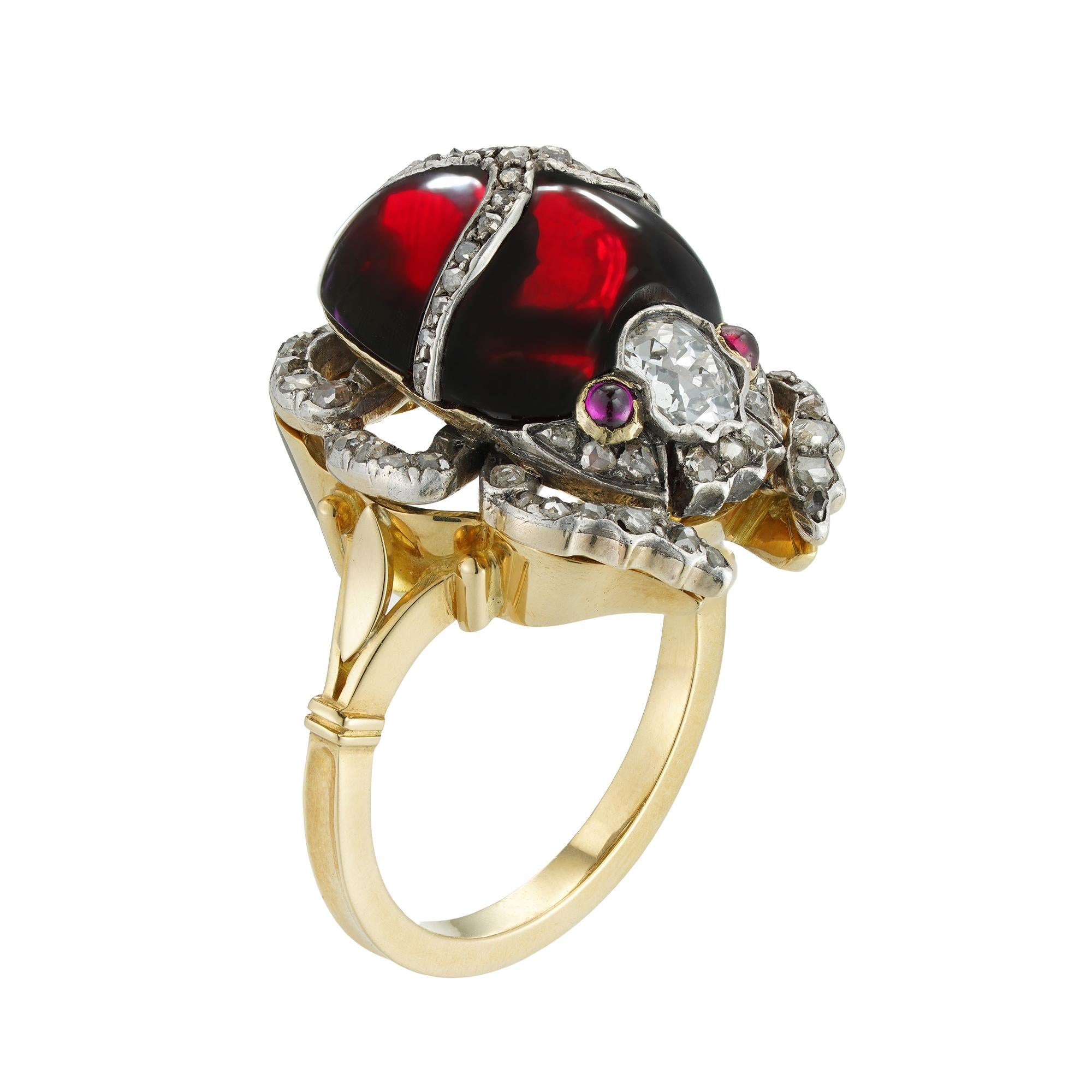 A Victorian garnet and diamond scarab pin/ring, the body of the scarab formed by a red cabochon-cut garnet applied with rose-cut diamond-set decorations , the head set with an old European-cut diamond estimated to weigh 0.3 carats and cabochon-cut